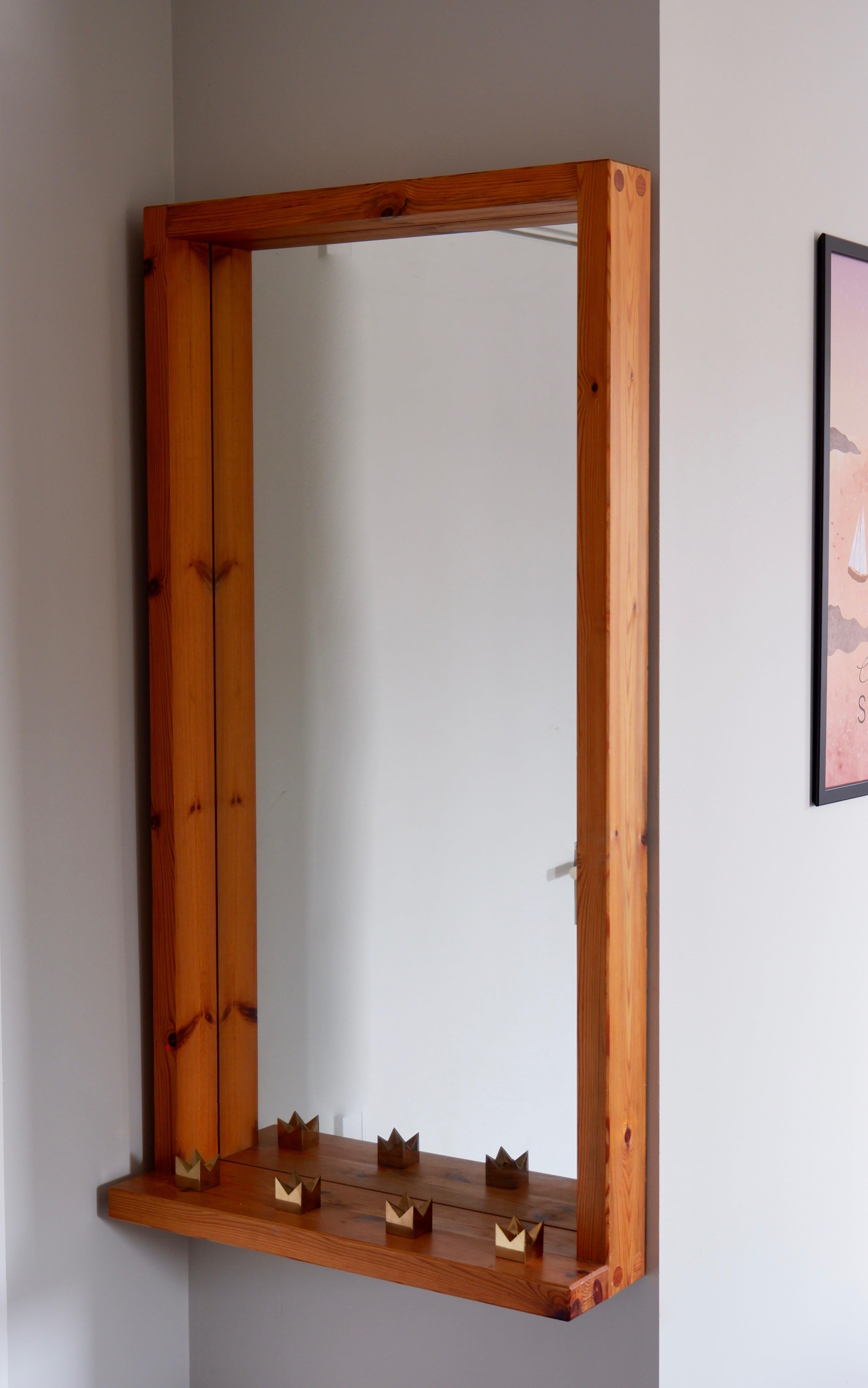 Important and massive pine wall miror attributed to Roland Wilhelmsson based on the style and the woods details. The miror is build with solid pine and as a tablet on its bottom part. The condition is really nice and has no structural damage at all.