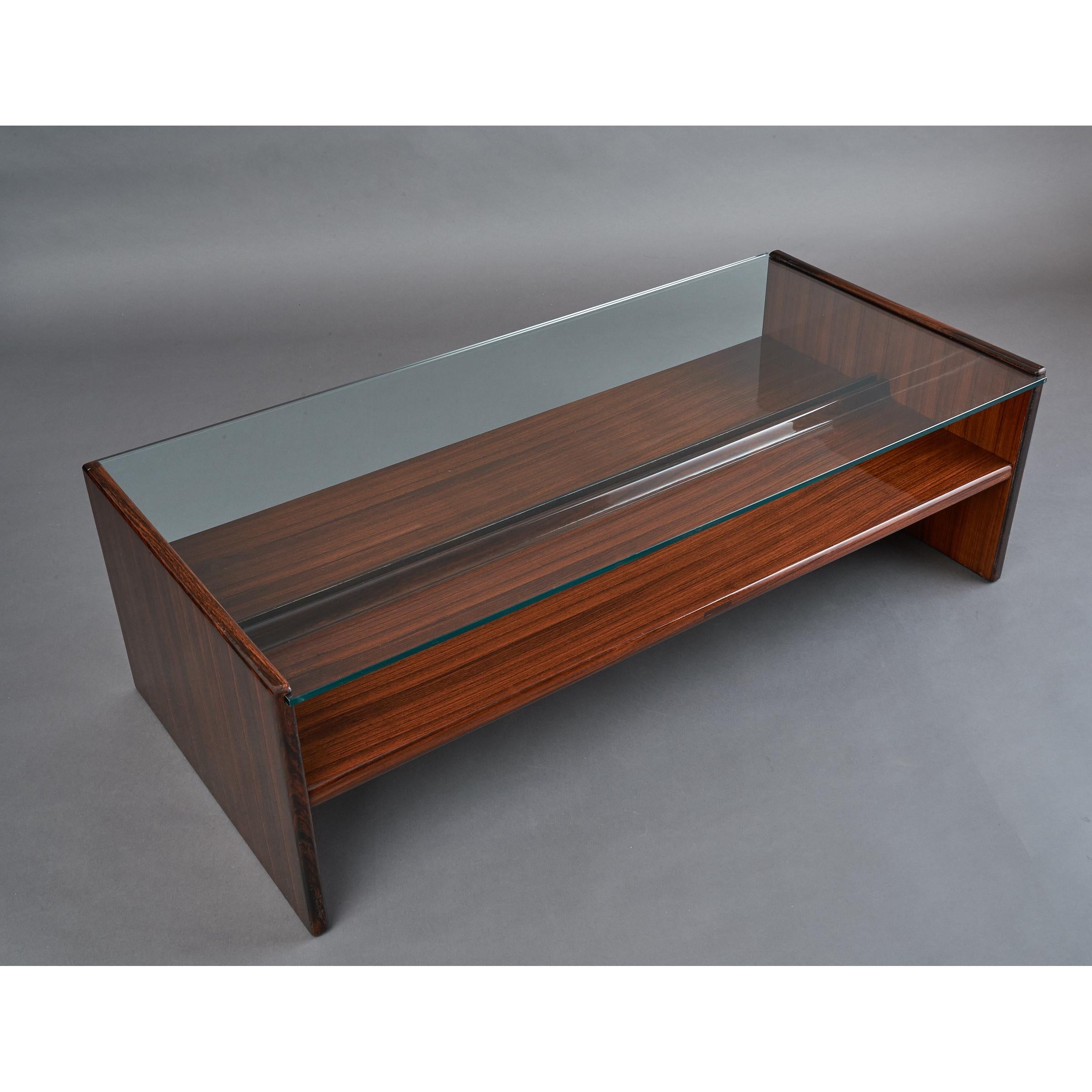 Italy, 1970s
Modernist long rectangular coffee table in beautifully grained wood veneer
with elegantly articulated shelf, clear glass top.
Measures: 51 W x 24.5 D x 16 H.