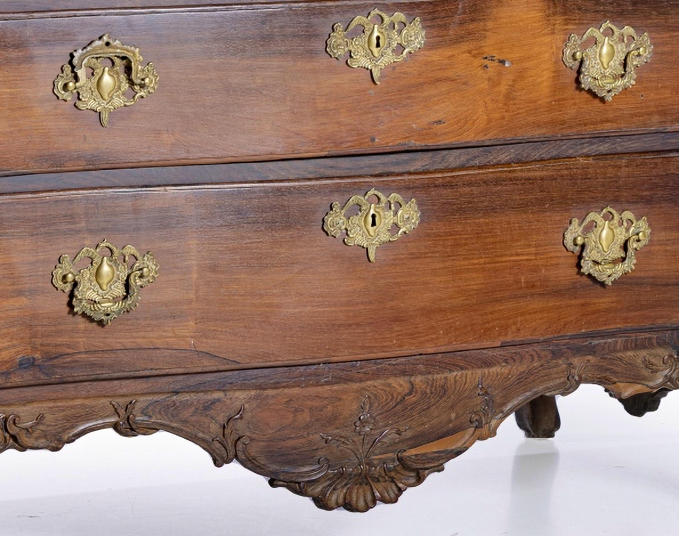 IMPORTANT PORTUGUESE COMMODE 18th century Rosewood

In rosewood wood, with 3 large drawers and 3 drawers.
Wavy and cut top, decorated with recess.
Cropped skirts decorated with floral elements.
Ending in pipe feet.
Small defects.
DIM.: 104 x