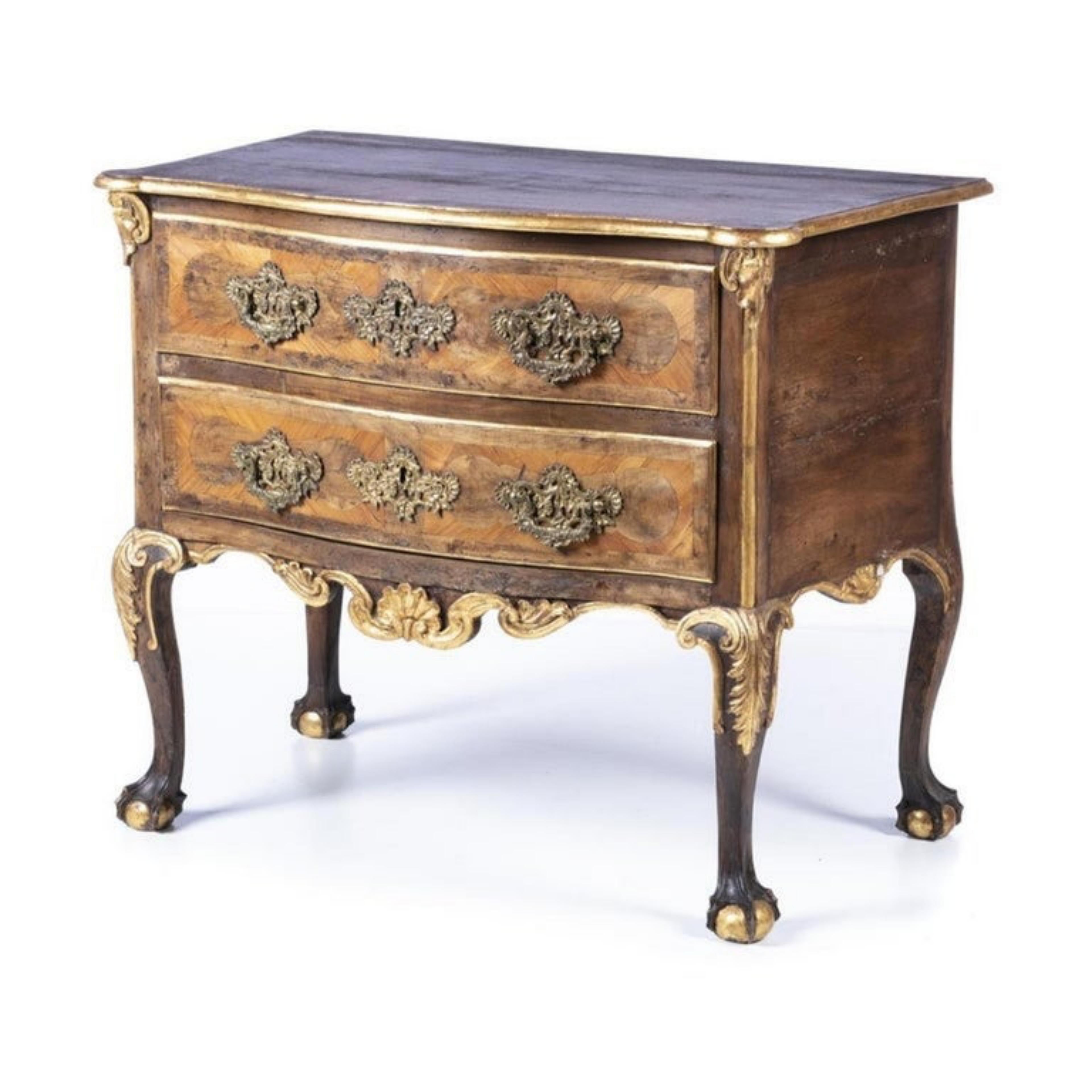 Portuguese dresser 18th century

in carved walnut wood and plated with other woods, with gilding. Box with two drawers and scalloped skirt, decorated with shell motifs and plant motifs. 
Stands on four feet in the shape of a claw and ball. 
Brass