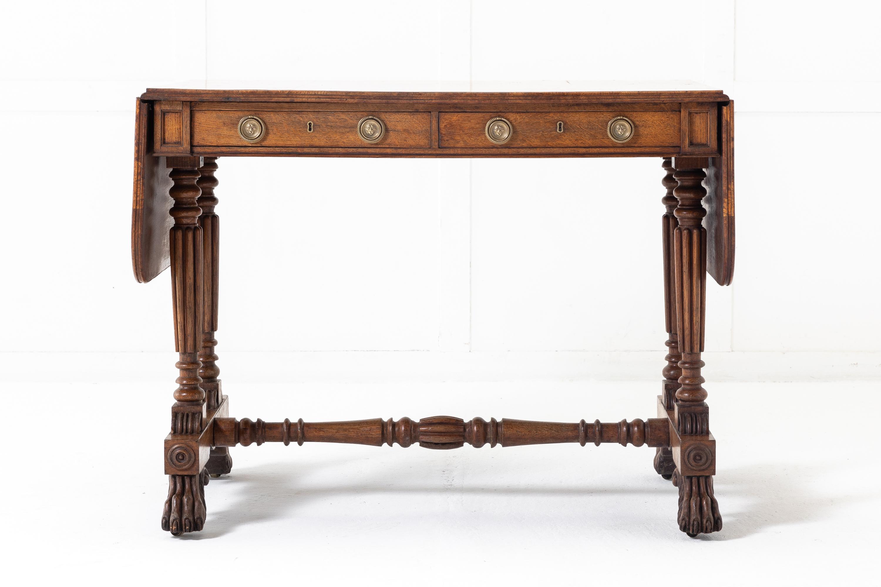 An important Regency oak and burr elm sofa table attributed to George Bullock. Having a moulded edge, burr elm top with outstanding colour. The frieze has two drawers and dummy drawers on the reverse side. Turned and fluted supports with fluted