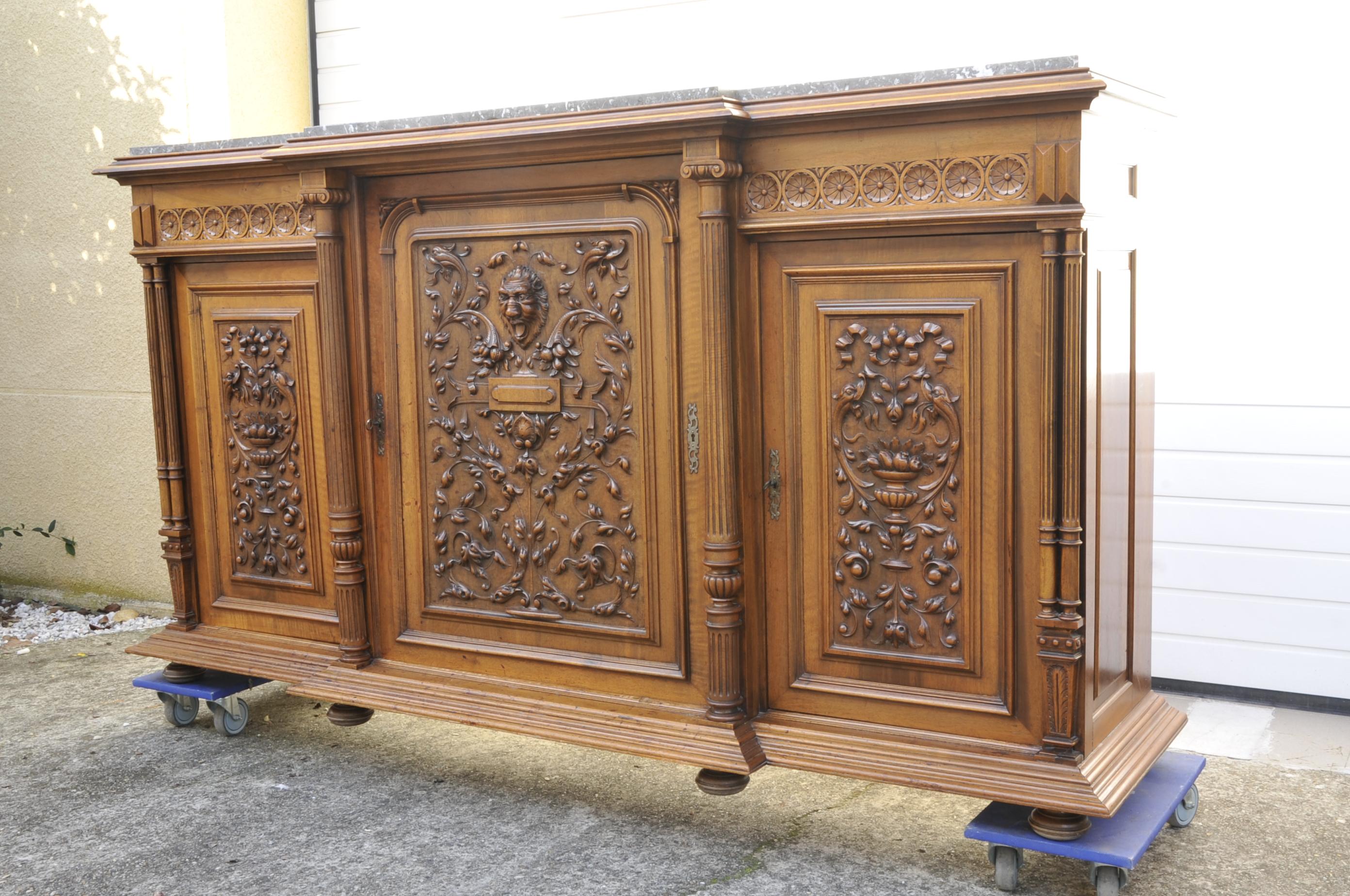 Renaissance-style sideboard in solid walnut opening 3 large doors with richly carved decoration, central projection, thick gray marble top (turquin blue), 6 detached columns on the front.

Good quality, dark oak.

Very imposing