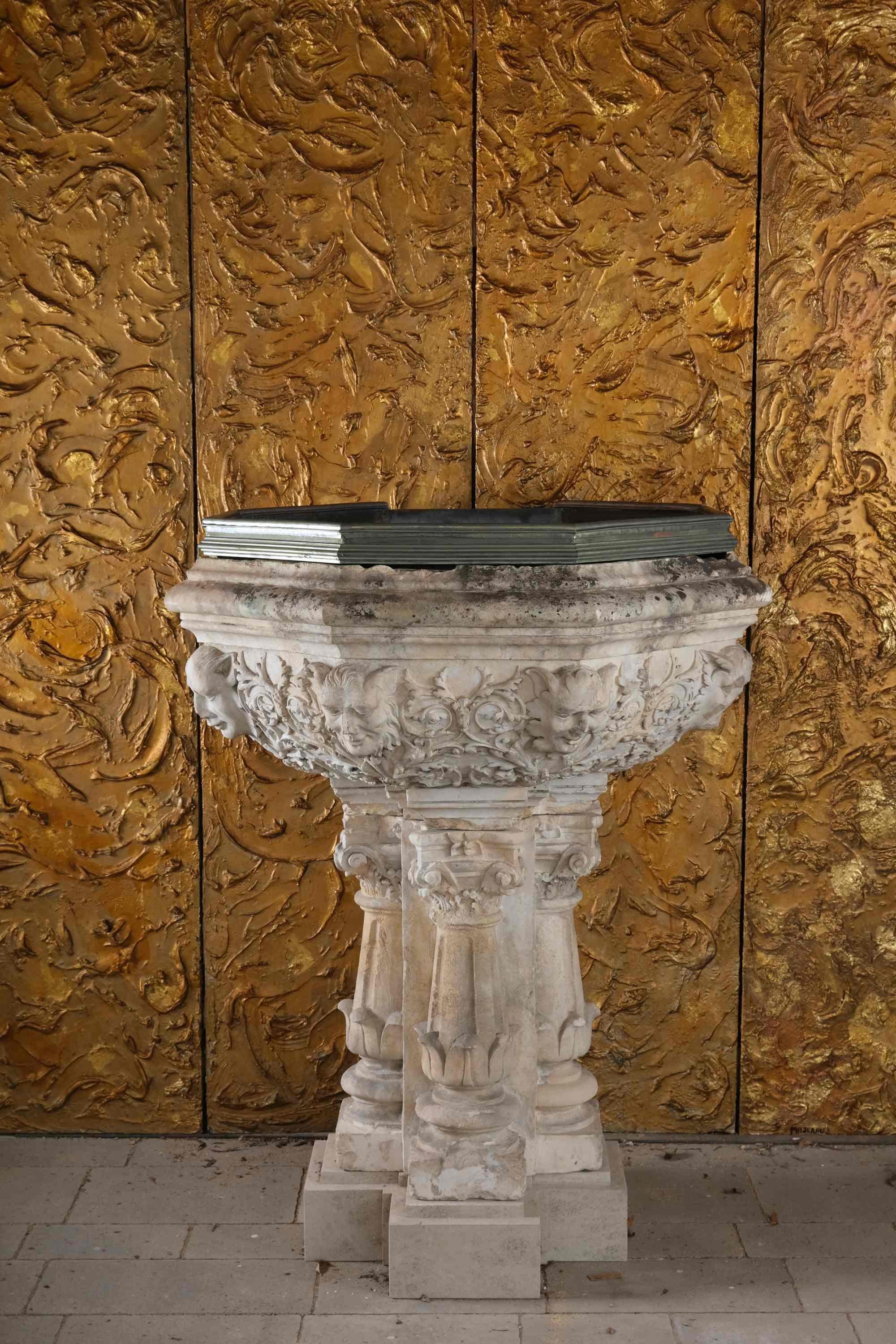 Round pilasters projecting on four sides, set on an offset plinth, support the flared octagonal basin. The quarter-round base is decorated with dense, mannerist foliage, partly still adorned with scrolled acanthus scrolls. At the corners, mystical