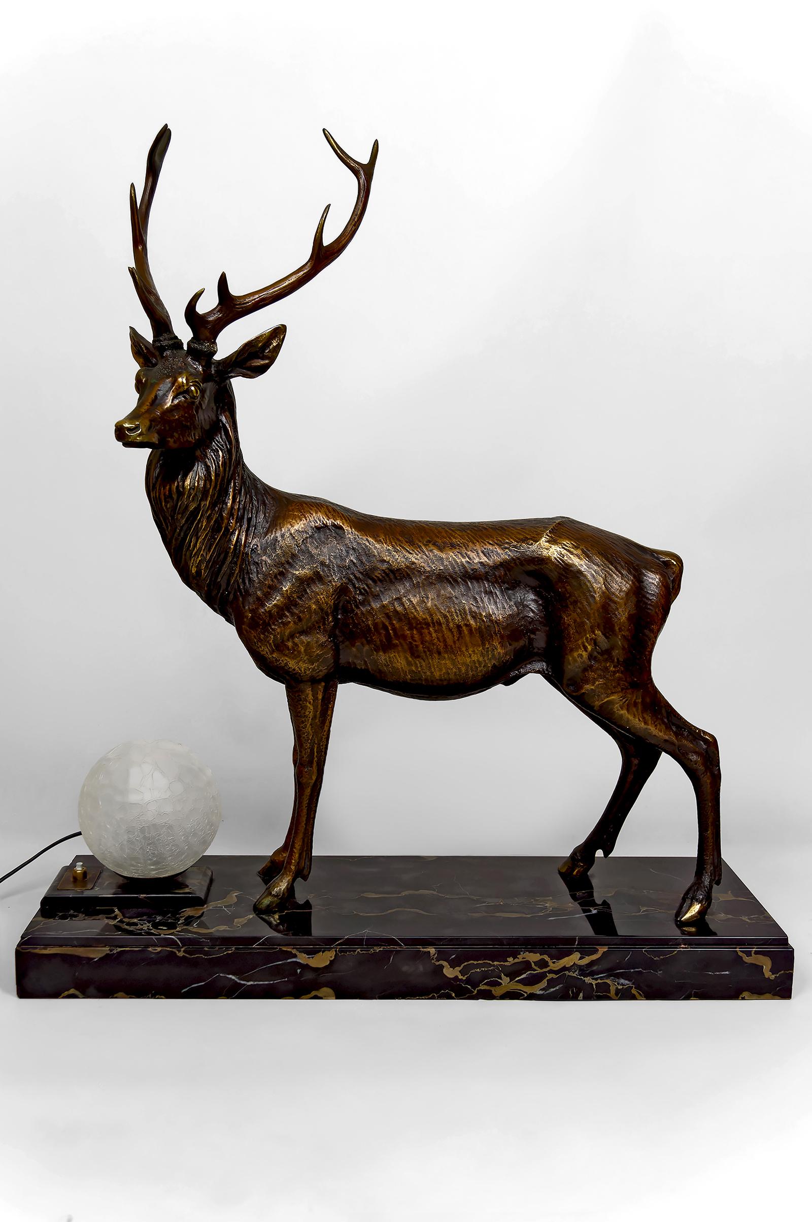 Nos complace ofrecer una pieza de iluminación excepcional y rara, emblemática del periodo Art Déco:
Una gran lámpara/linterna escultórica de bronce patinado, que representa a un majestuoso ciervo con un realismo sorprendente.
El animal está colocado