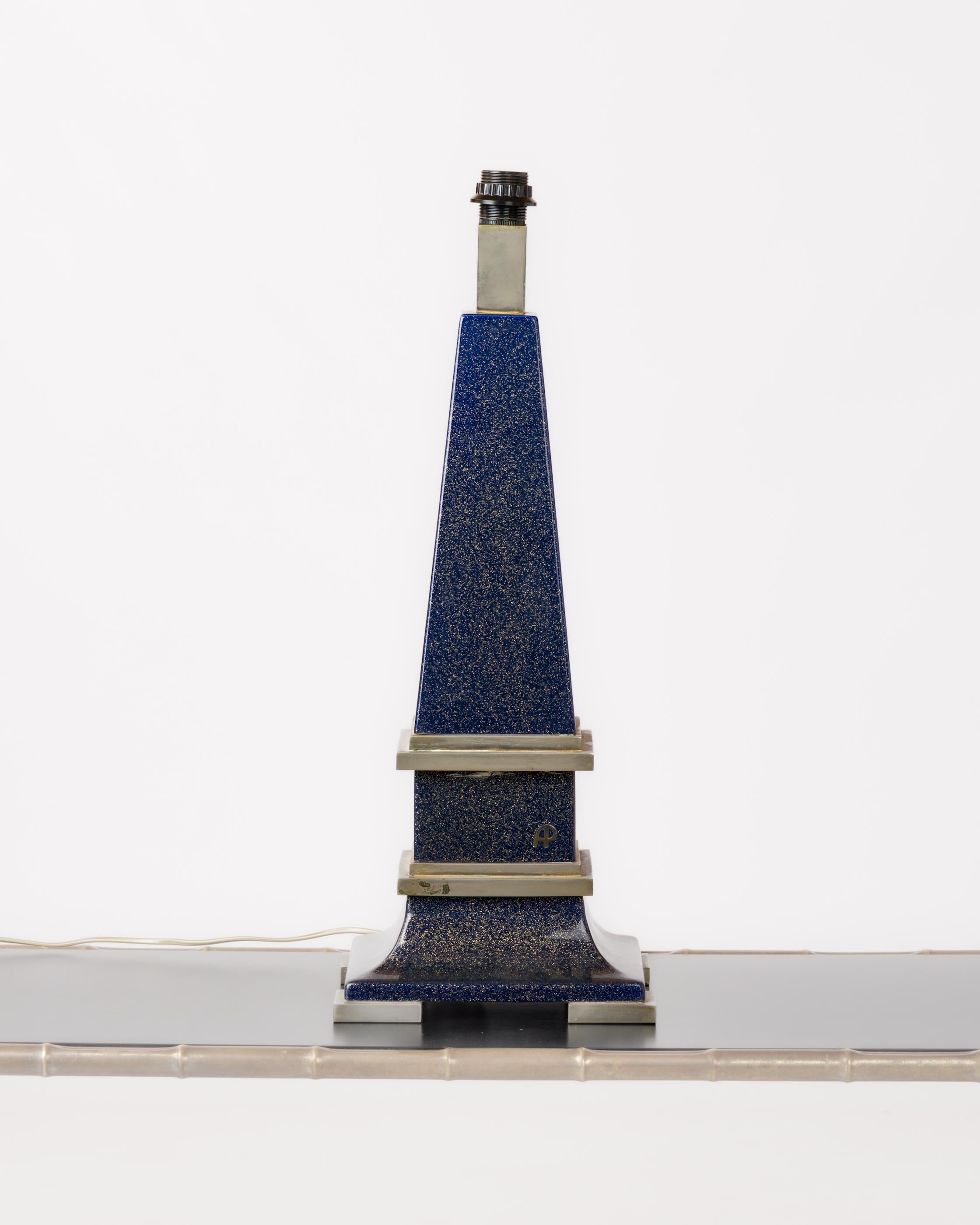Lámpara de mesa de los años 70, atribuida a Claude Dalle. De acero niquelado y cuerpo de resina azul brillante, con una firma incrustada en el cuerpo de la lámpara. Forma piramidal.
Enchufe y cableado europeos. La sombra sólo sirve para