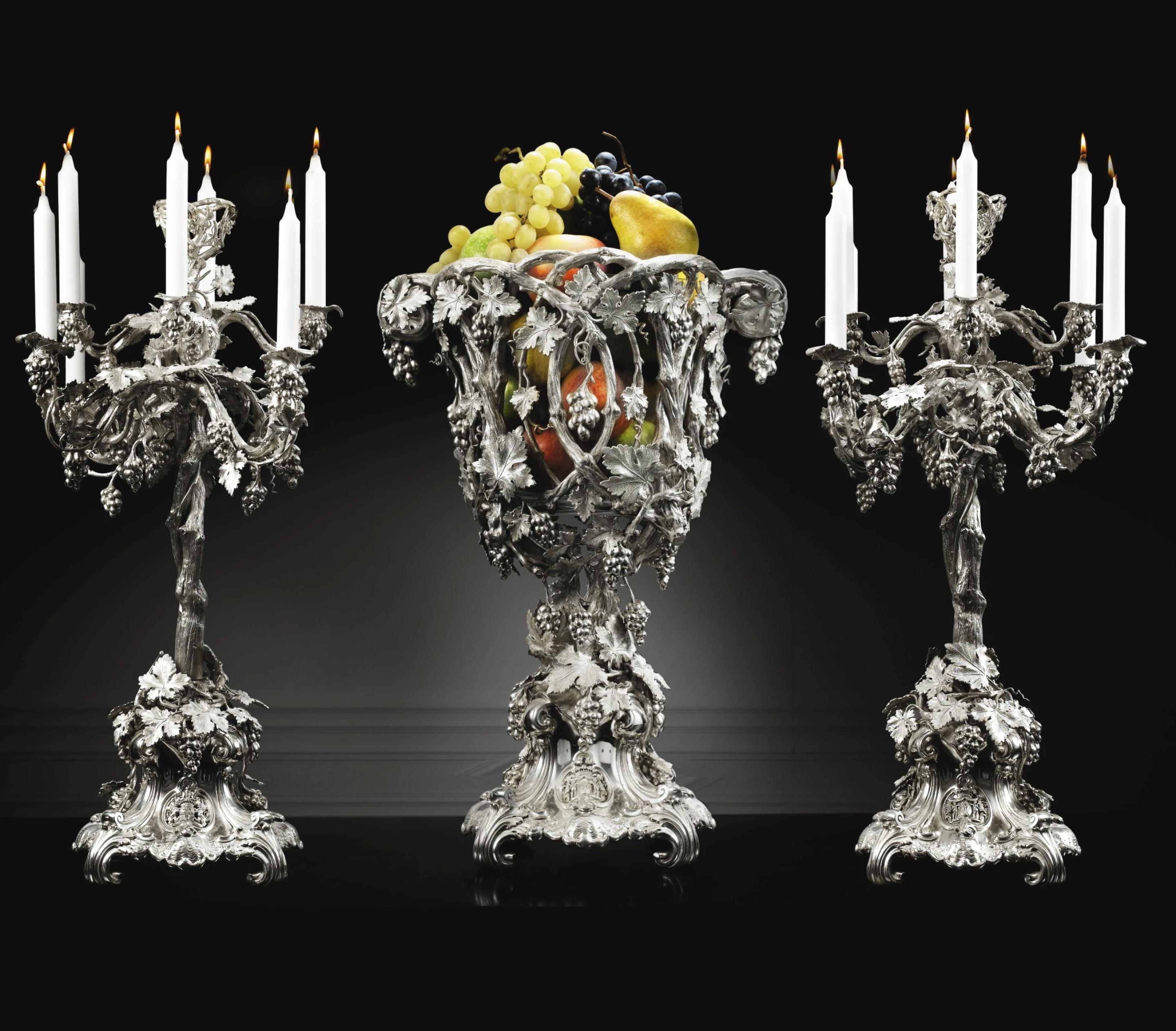 Importante parure da tavola in argento composta da una coppia di grandi candelabri a otto luci e da un centrotavola, opera di Heinrich Friedeberg, Berlino, 1850-1860 ca.

Descrizione
Importante parure da tavola in argento composta da una coppia di