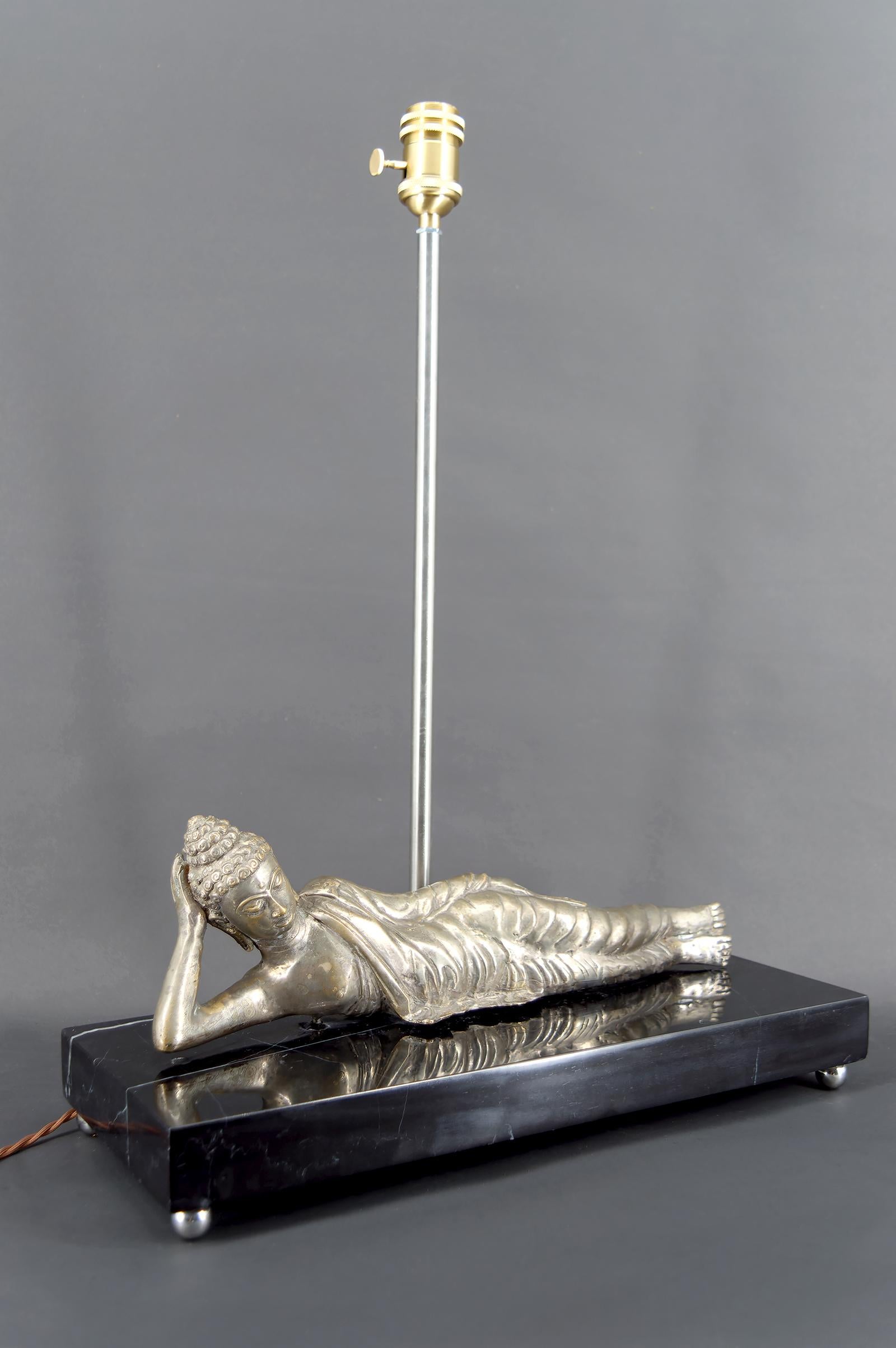Importante lampe bouddha en bronze argenté sur socle en marbre noir
Ancienne Indochine française, Circa 1930-1940

Elegante et rare, cette lampe de grande qualité représente un bouddha couché en méditation, finement sculpté en bronze argenté et