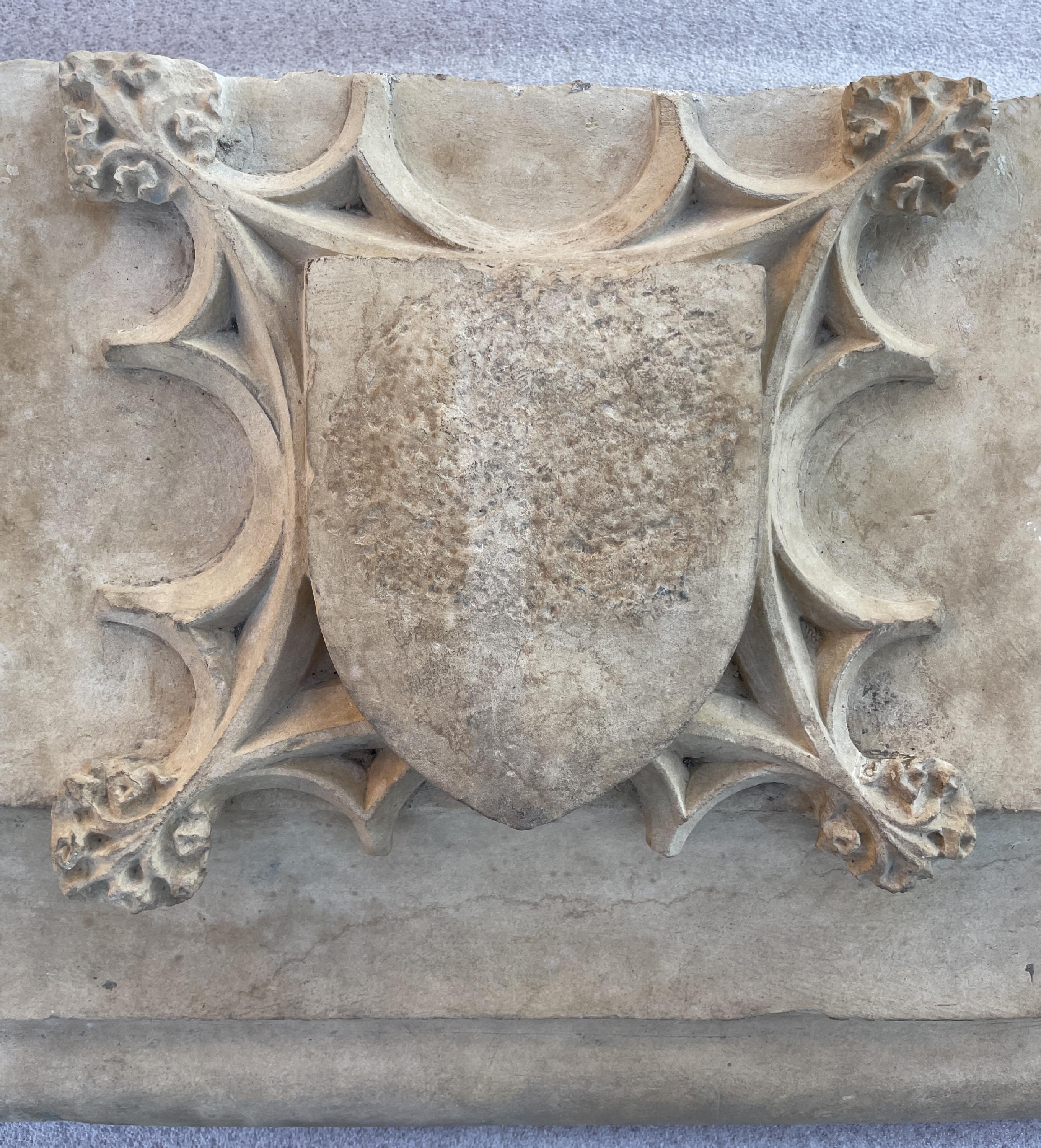 Dieser monumentale Kaminsims wurde im 17. Jahrhundert aus Stein gefertigt.
Das profilierte Gebälk, das mit einem Wappen in gotischem Dekor verziert ist, ragt aus den Türpfosten heraus.