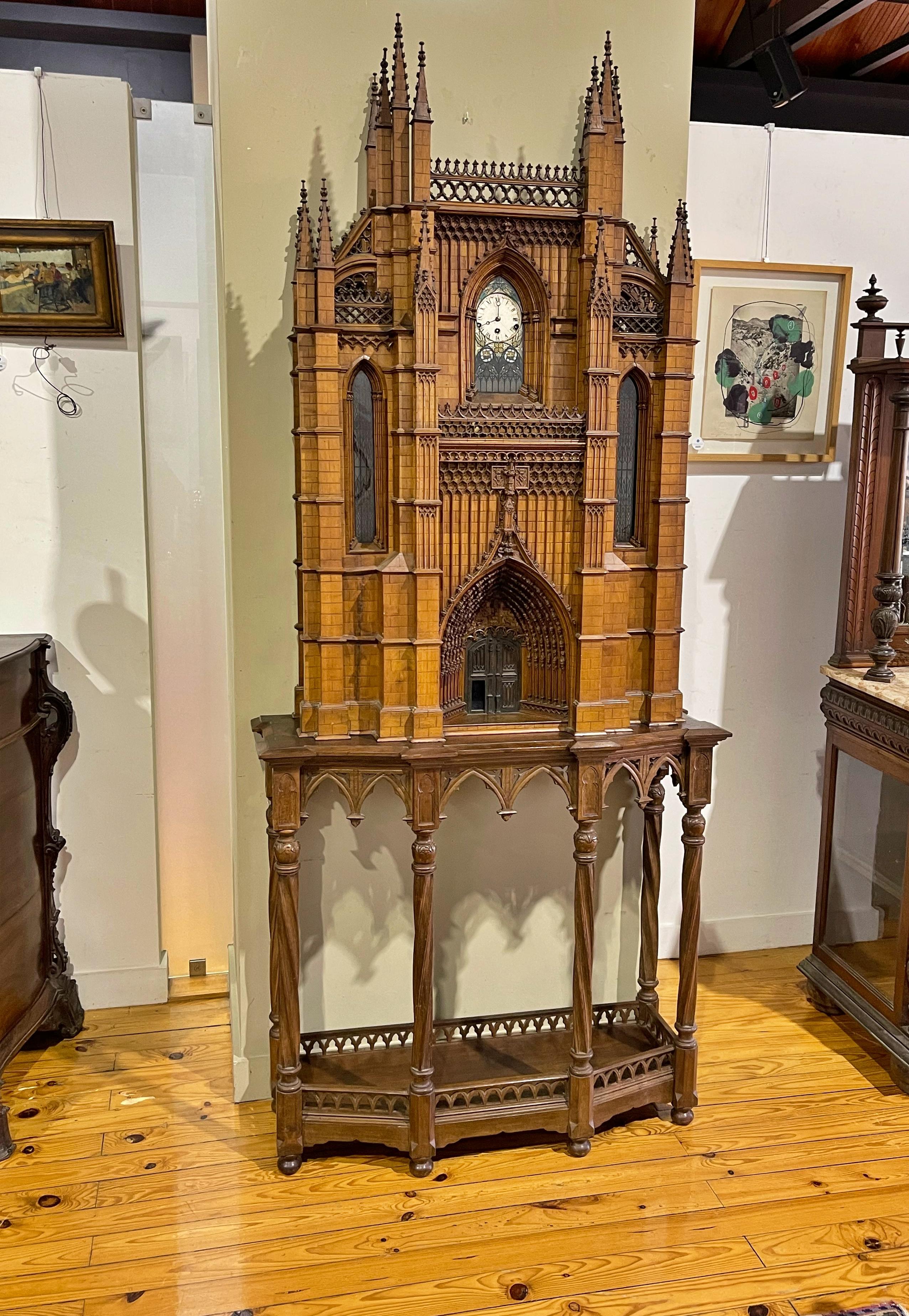 Important table clock
possibly French
of the 19th century 
shaped like a gothic cathedral.
Dial with roman numerals.
It rests on an oak table.
Clock running not revised.
Dim.: (clock) 139 x 89 x 24 cm
Dim.: (table) 93 x 100 x 28 cm.
good
