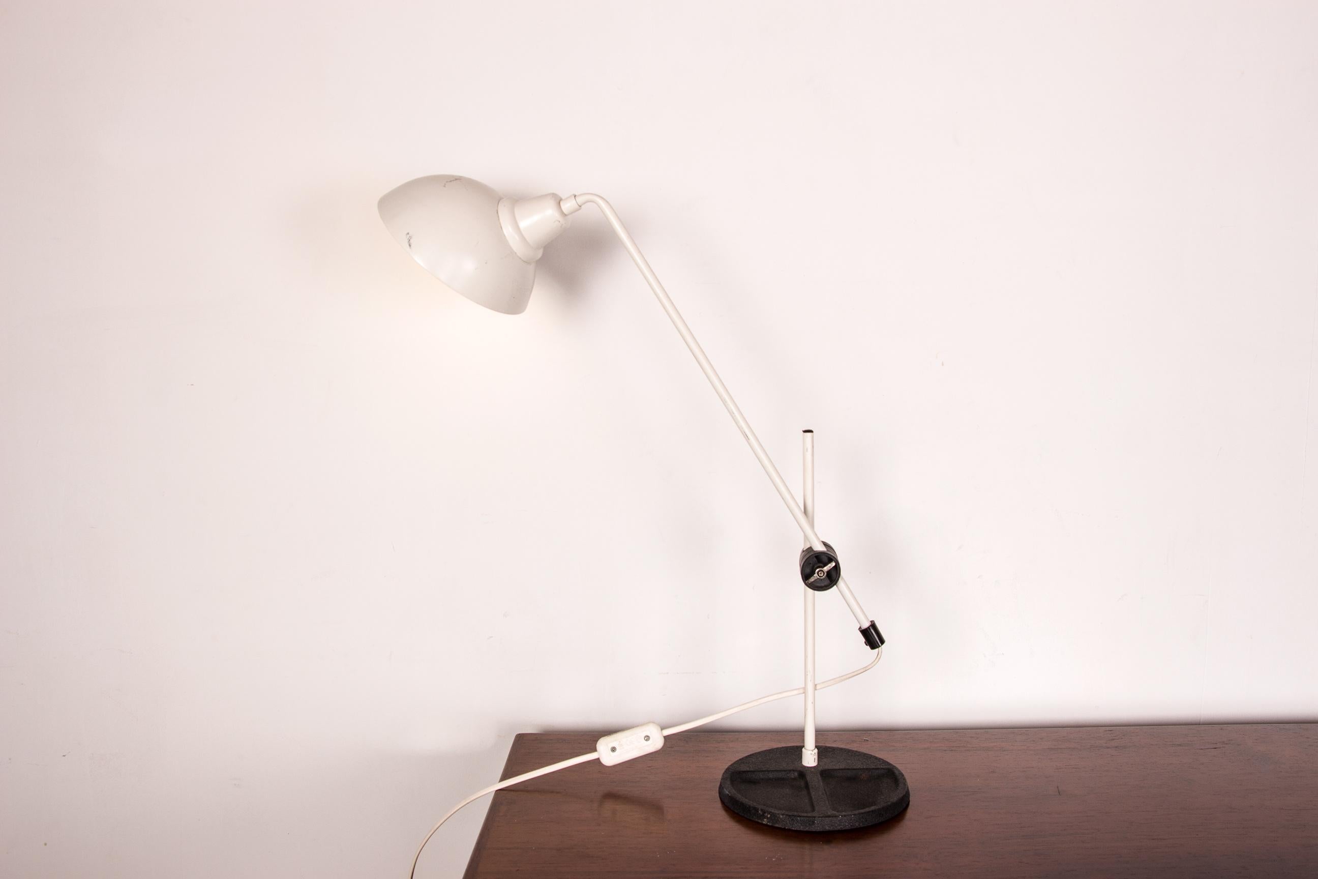 Pretty large desk lamp with articulated arm, on hammered steel base with storage spaces. Light cover in the shape of a half-globe.