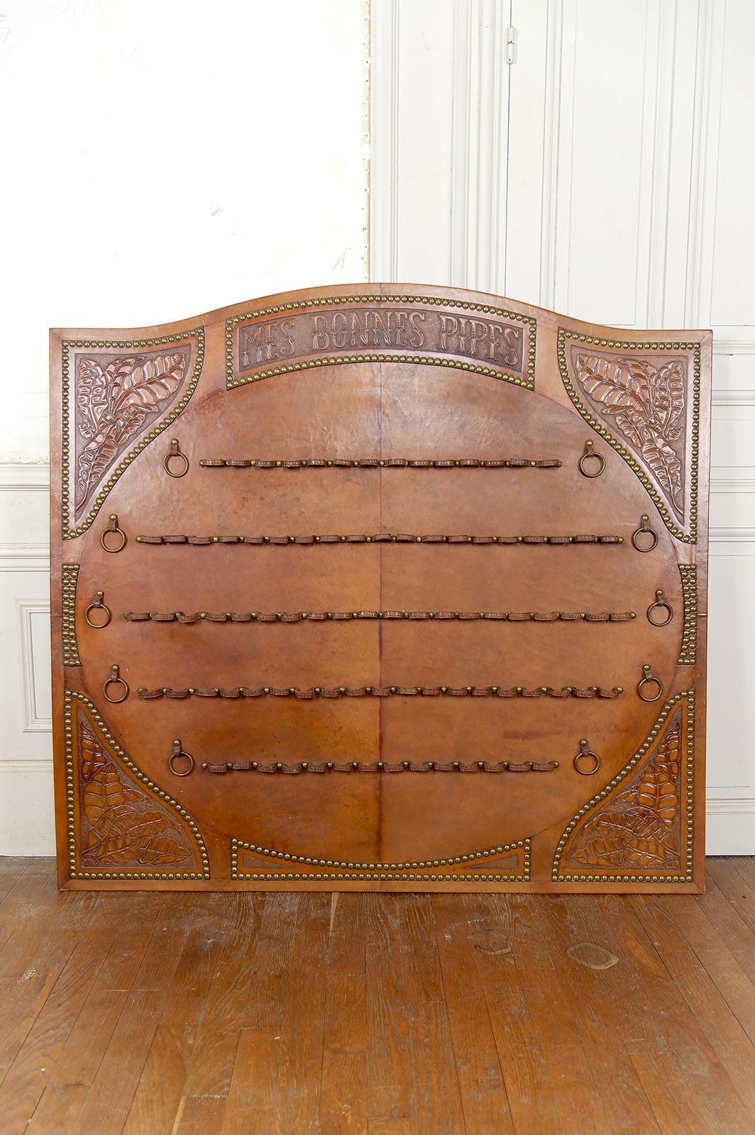 Nous avons le plaisir de vous présenter une pièce exceptionnelle : un porte-pipe à tabac en cuir repoussé, pièce rare et majestueuse du XXe siècle, alliant un savoir-faire de haut niveau à l'influence des principaux mouvements artistiques de