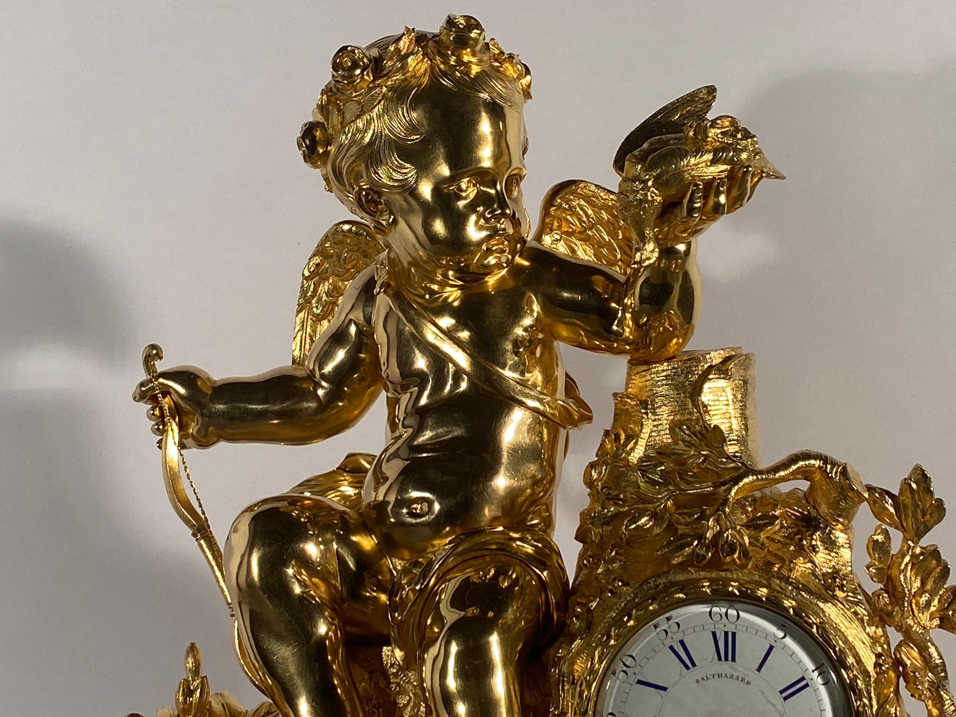 Spectacular trim consisting of a clock and its candelabras decorated with Cupid sits on a tree stump.
In Roman mythology, Cupid, son of Venus and Mars, is the god of love. The original gilding is of exceptional quality and in a unique state of