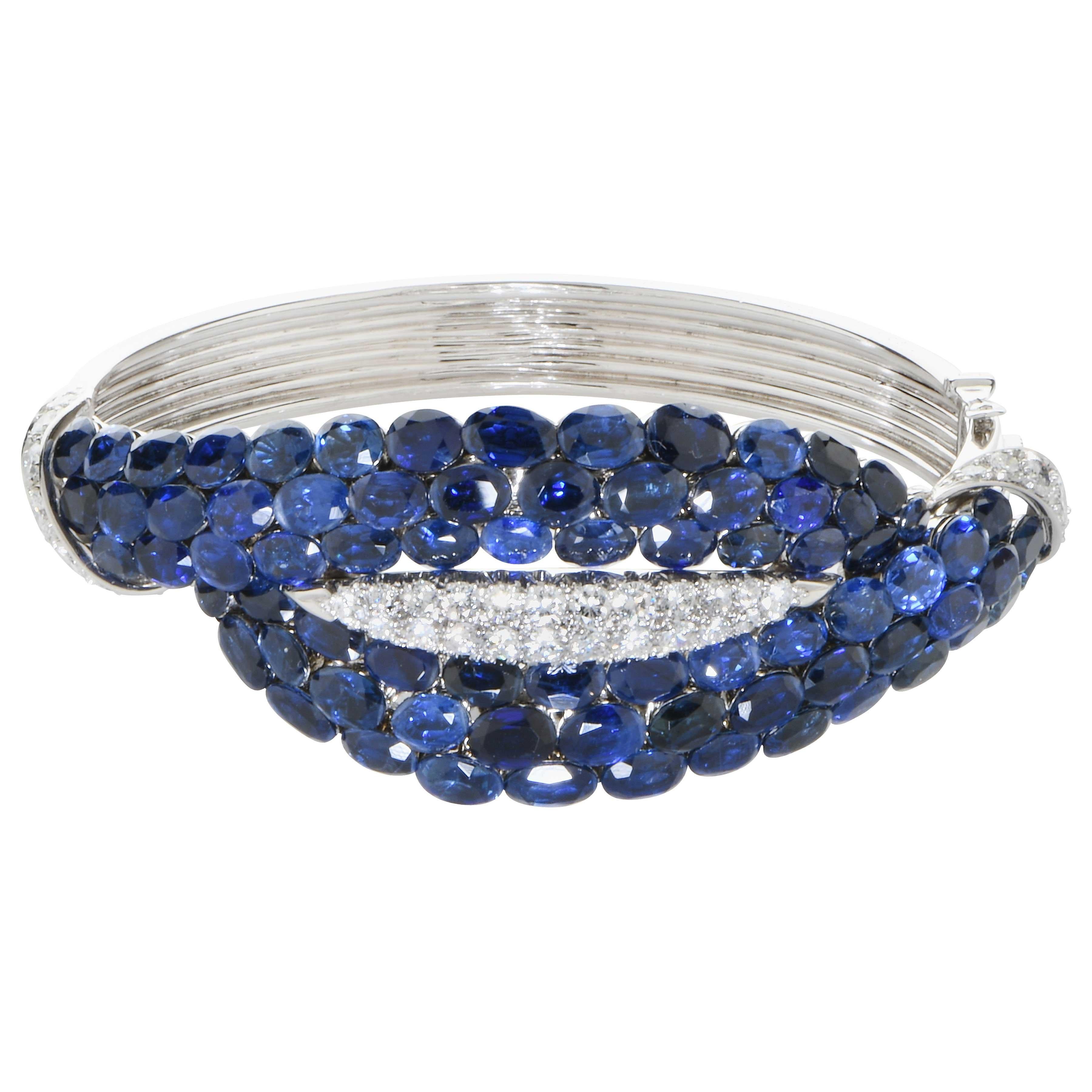 This Important and Rare Van Cleef & Arpels hand crafted beautiful bangle features 76 oval cut sapphires and 36 round brilliant cut diamonds hand set in Platinum and 18 Karat White Gold. Circa 1963.
This wonderful bracelet will become the signature