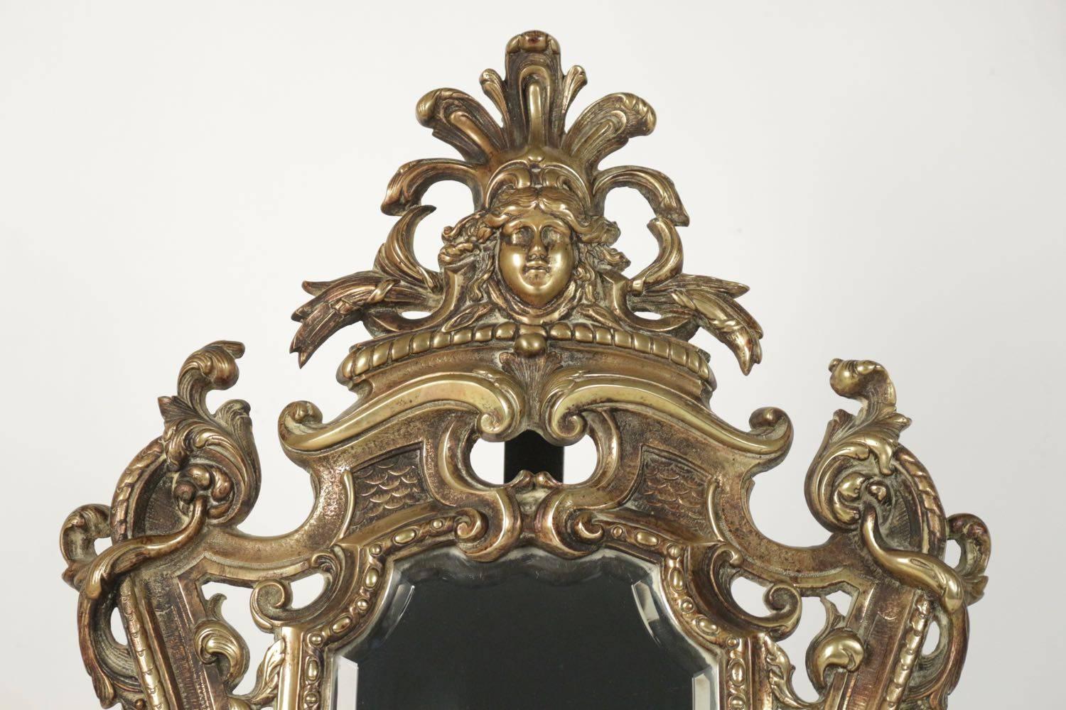 Important miroir de courtoisie en bronze patiné du 19ème siècle avec miroir au mercure d'origine.
Dimensions : 60 cm x 37 cm x 4 cm : 60cm x 37cm x 4 cm.
 