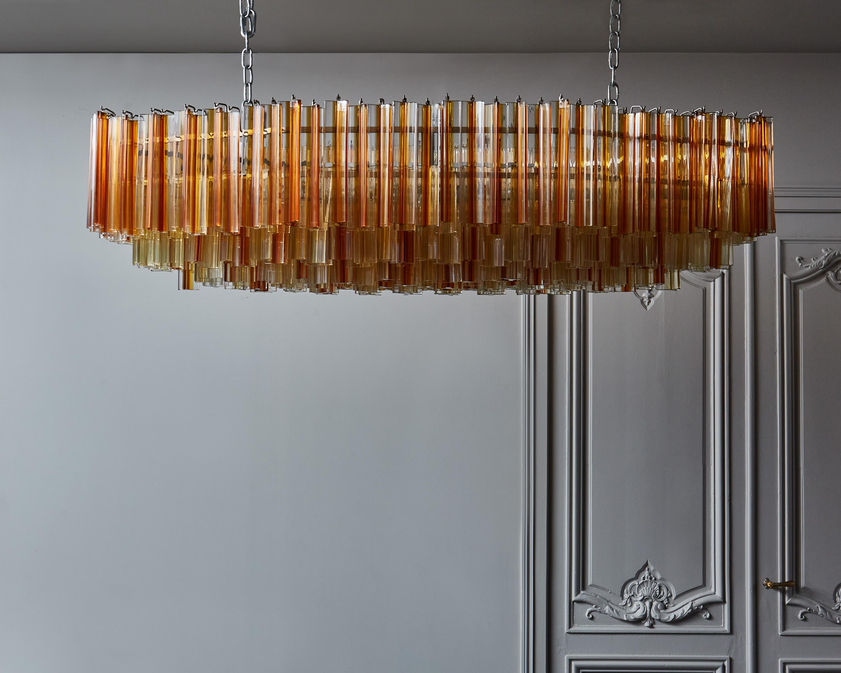 Absolutely massive mid-century hexagonal chandelier made of a metal structure and tens of large triedri Venini glass parts. The clear, champagne and orange of the glass provide a soft golden light. Special order from galerie François Belet for an