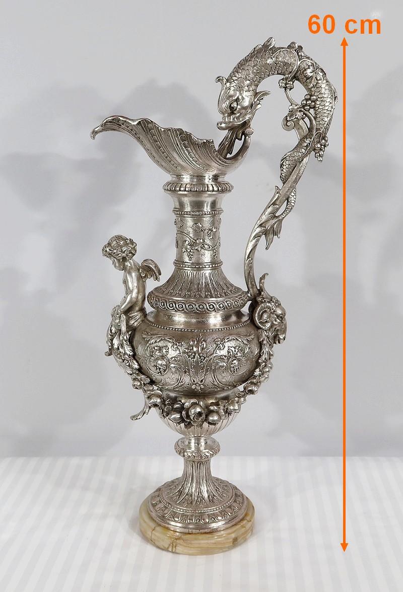 Magnifica e grandissima anfora decorativa in argento in stile Luigi XVI. È decorato con fogliame, intrecci e volute. Numerose foglie di vite e grappoli d'uva adornano il corpo di questo oggetto, accompagnato da numerose ghirlande di perle.
Il manico