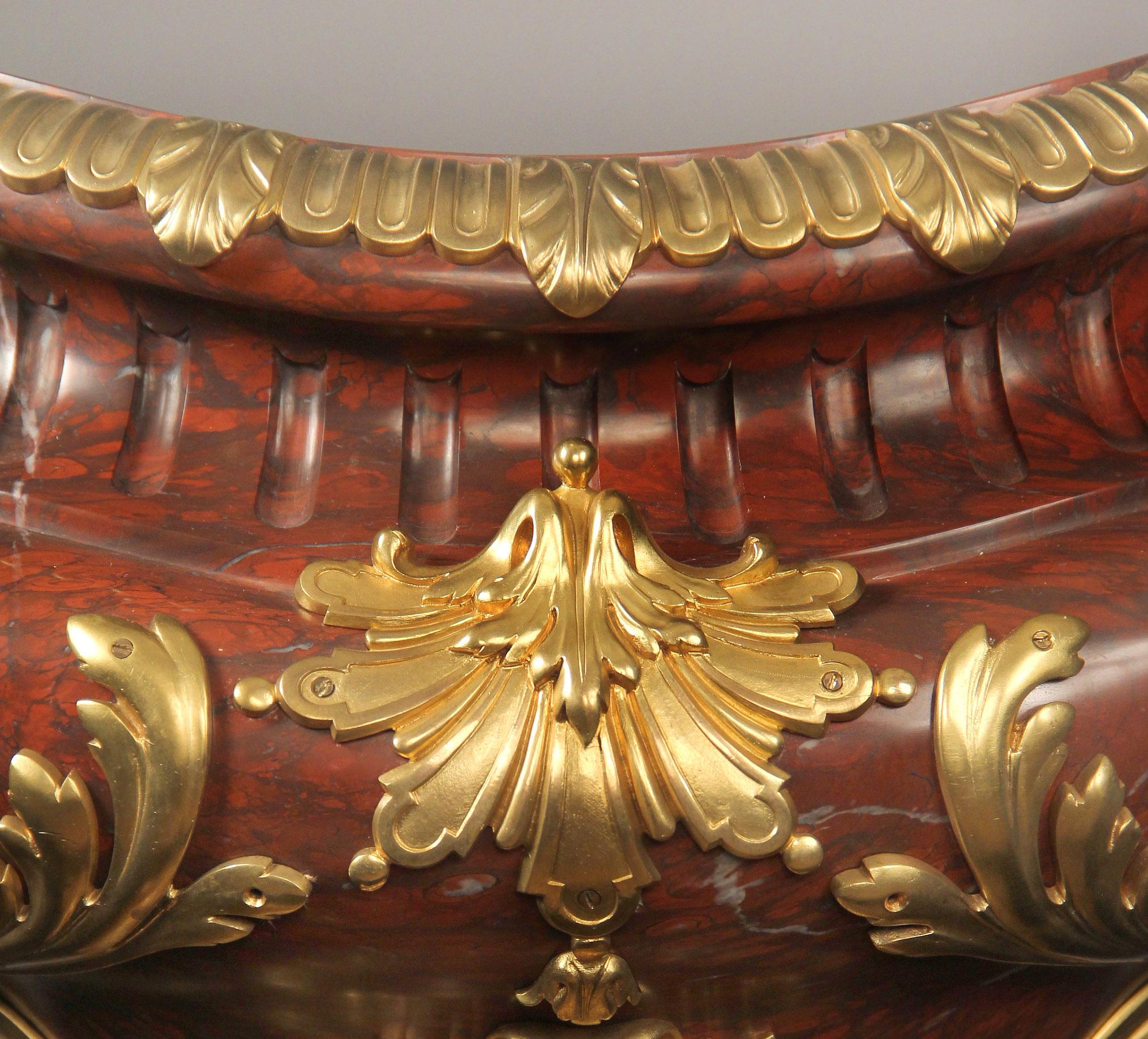 An imposing late 19th century Napoleon III gilt bronze mounted rouge griotte marble jardiniere by Barbedienne

Ferdinand Barbedienne

The oval waisted neck with gadrooned surround mounted with acanthus leaves, the bulbous body centered to the