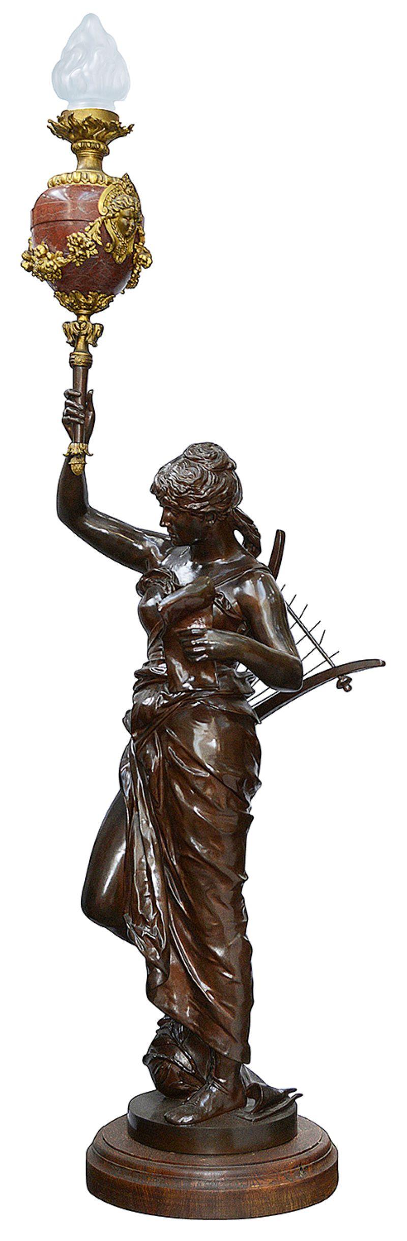 This very fine patinated bronze figural torchere modeled as a classically clad female musician holding a mandolin and a marble torch. This symbolic representation of Music, falls within Coutan’s allegorical work. 
We have a number of marble