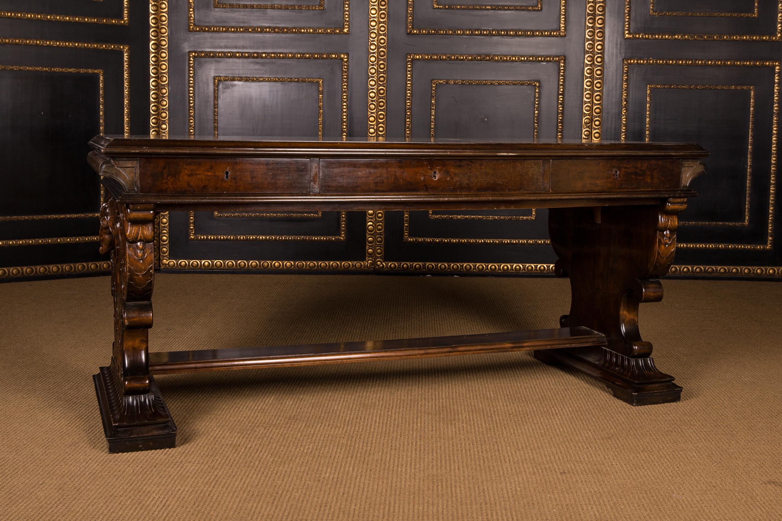 Oakwood. Straight body ending on curly, volute-shaped legs. Richly carved on all sides. Slightly protruding tabletop, including the middle drawer. The desk is free in the room.
 