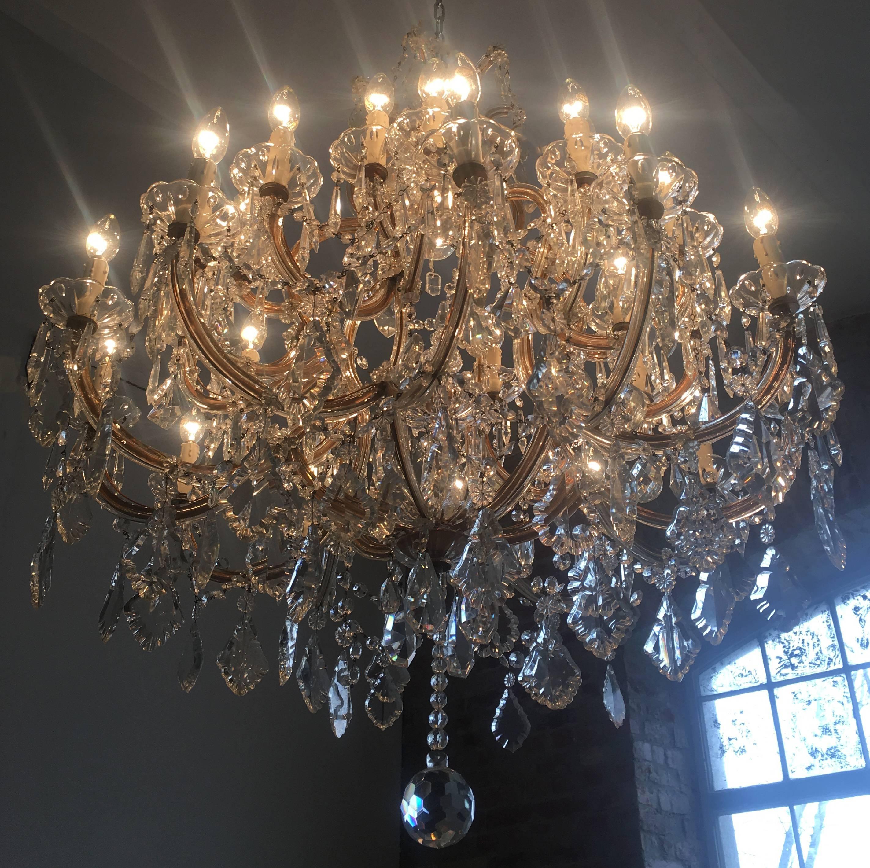 An elegant crystal chandelier 'Maria Theresa' with 30 light fittings and one central light.
This beautiful chandelier is embellished with clear Bohemian crystal pendeloques, flower rosettes and octagons.
In the centre, there is a cut coupe with an