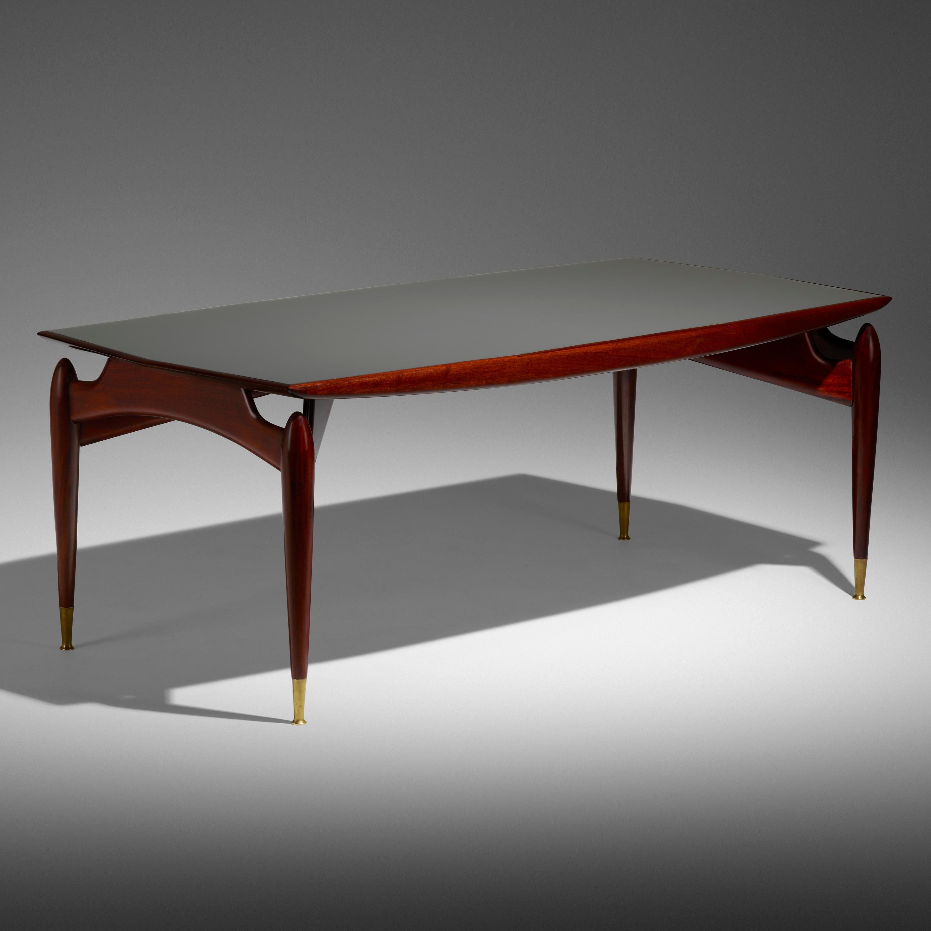 Giuseppe Scapinelli (1891 - 1982)

An imposing and elegant dining table or writing table by Italian-Brazilian designer Giuseppe Scapinelli, in mahogany with a fully opaque, back-painted glass top and brass sabots. The rectangular top, which is