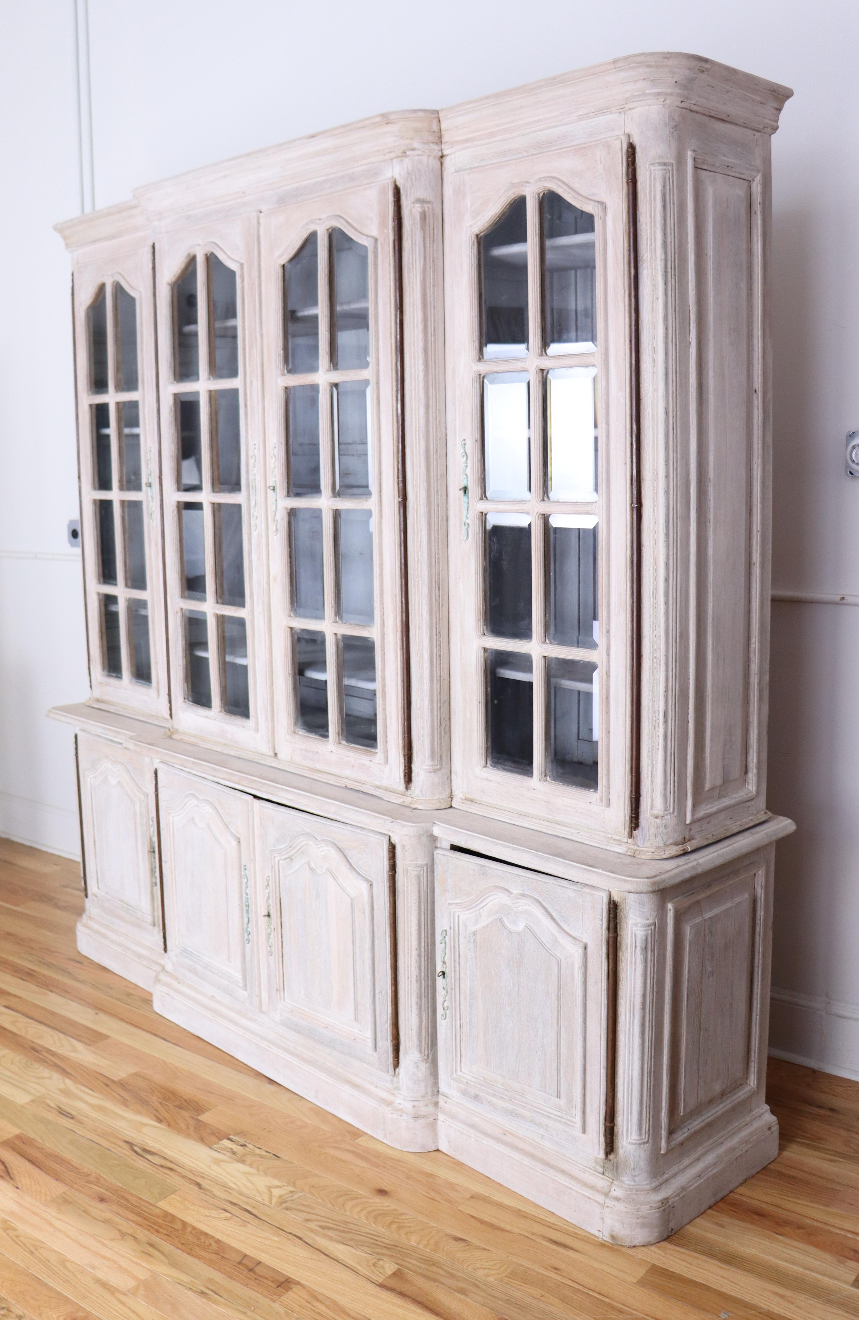 An elegant Belle Epoque oak bookcase, bleached for a clean and modern look. Top and bottom components in two pieces for easy transport, with adjustable shelves on the top. The interior of this piece has been newly painted a serene light blue/gray. 