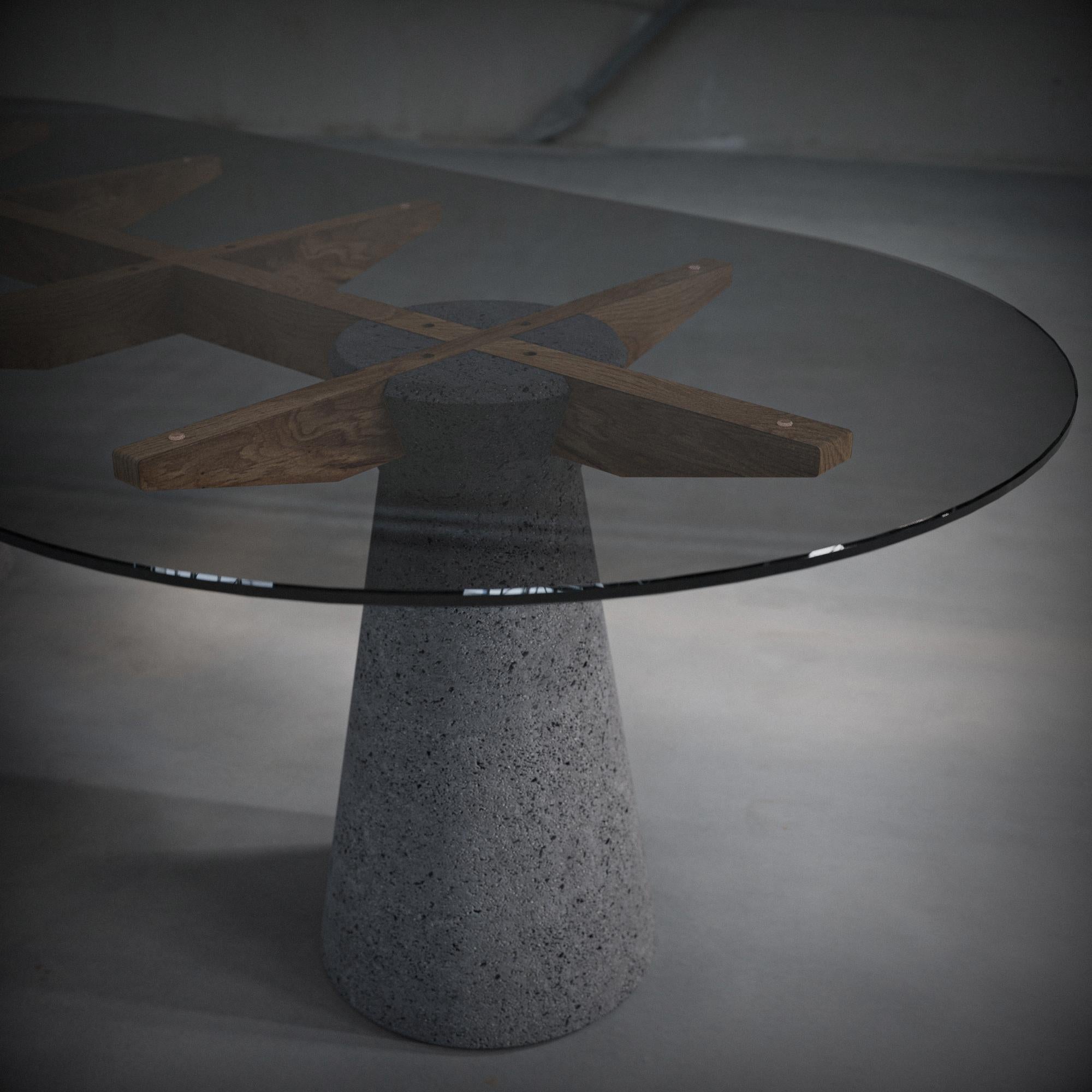 Questo tavolo da pranzo presenta un sorprendente design brutalista, con basi monolitiche in pietra lavica che fungono da audaci elementi di base. Le croci, realizzate in legno massiccio, forniscono un supporto strutturale e contrastano con la