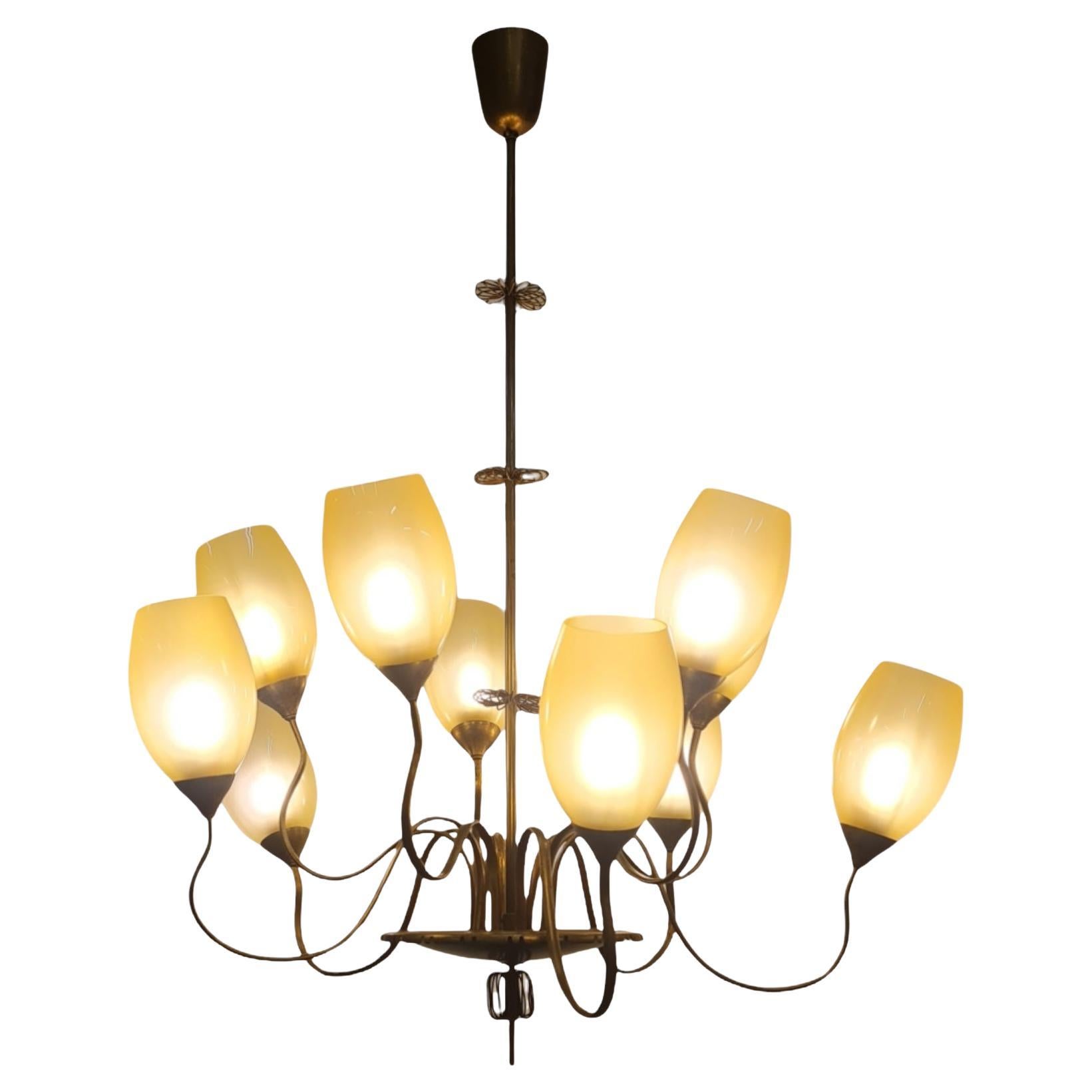 Un impressionante lampadario a dieci bracci a medusa modello 9017 di Paavo Tynell per Taito. Questa grande lampada da soffitto ha, come detto, dieci bracci ondulati di diverse altezze uniti al centro da un grande piatto in ottone con una decorazione