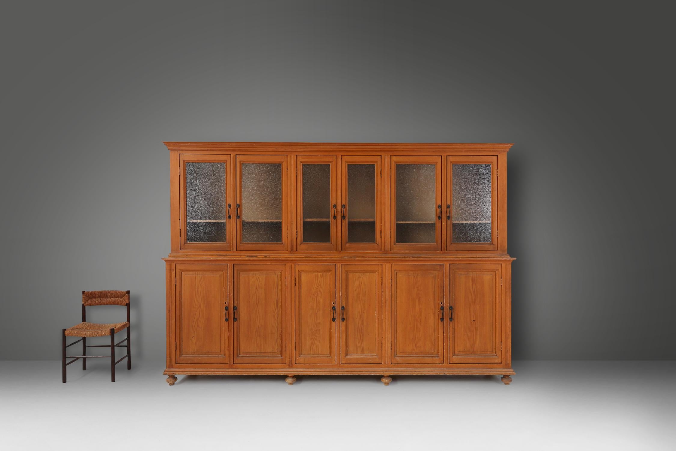Belgium / 1890 / monastery cabinet / pine wood, figured glass / antique / mid-century / rustic

An impressive Belgium monastery or display cabinet in pine with 6 wood doors on the bottom and 6 figured glass doors on top. With 6 large compartments