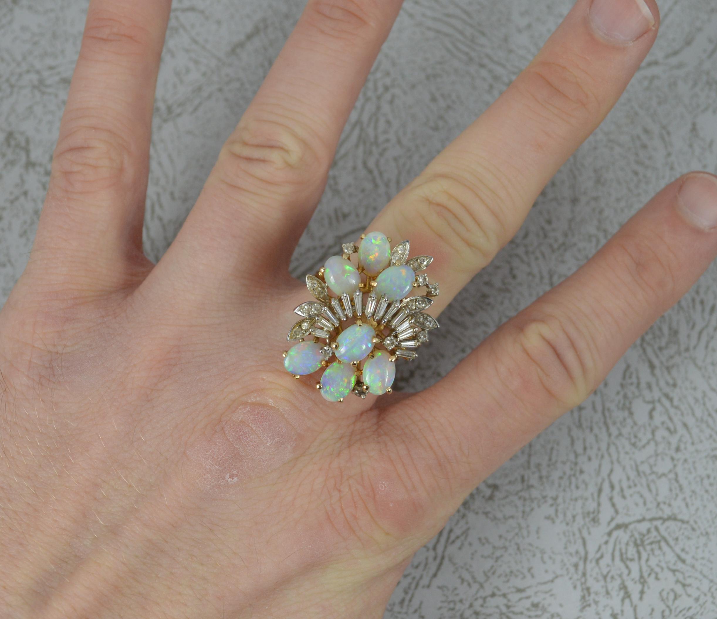 A superb vintage cluster ring.
Solid 14 carat yellow gold example.
A total statement piece comprising of seven oval shaped natural opals, each full of colour and well matched. Many baguette cut diamonds run through the cluster with further smaller
