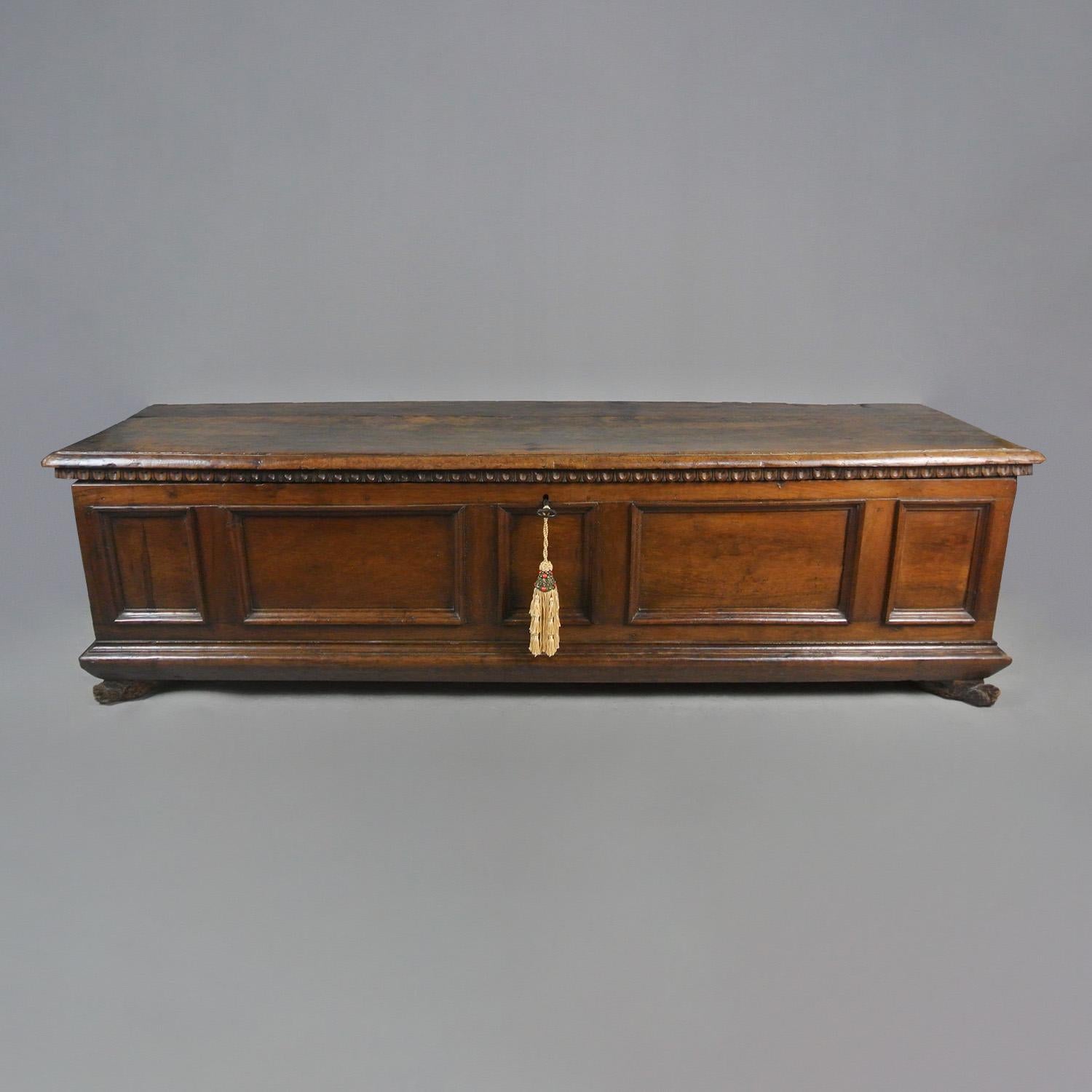 A very wide and beautiful sword chest in solid walnut and of superb colour and patination.

The chest is set on carved lion paw front feet and retains its original snaped iron hinges and original iron lock and key.

With egg and dart border to the