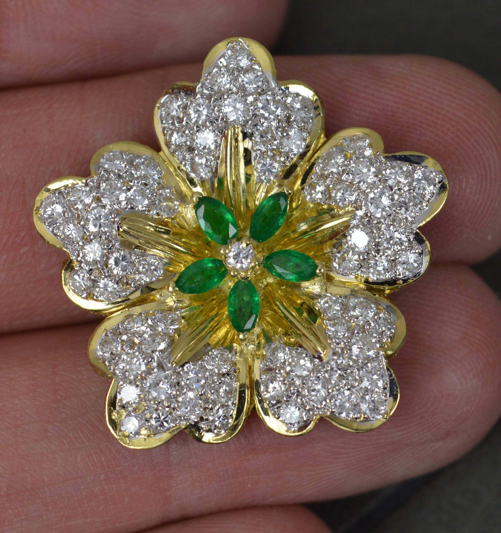 
A superb vintage flower shaped pendant.

Solid 18 carat yellow gold example.

Designed with 70 round brilliant cut diamonds pave set into the five petals and a centre stone with five marquise cut emeralds surrounding. 1.5 carat total diamond
