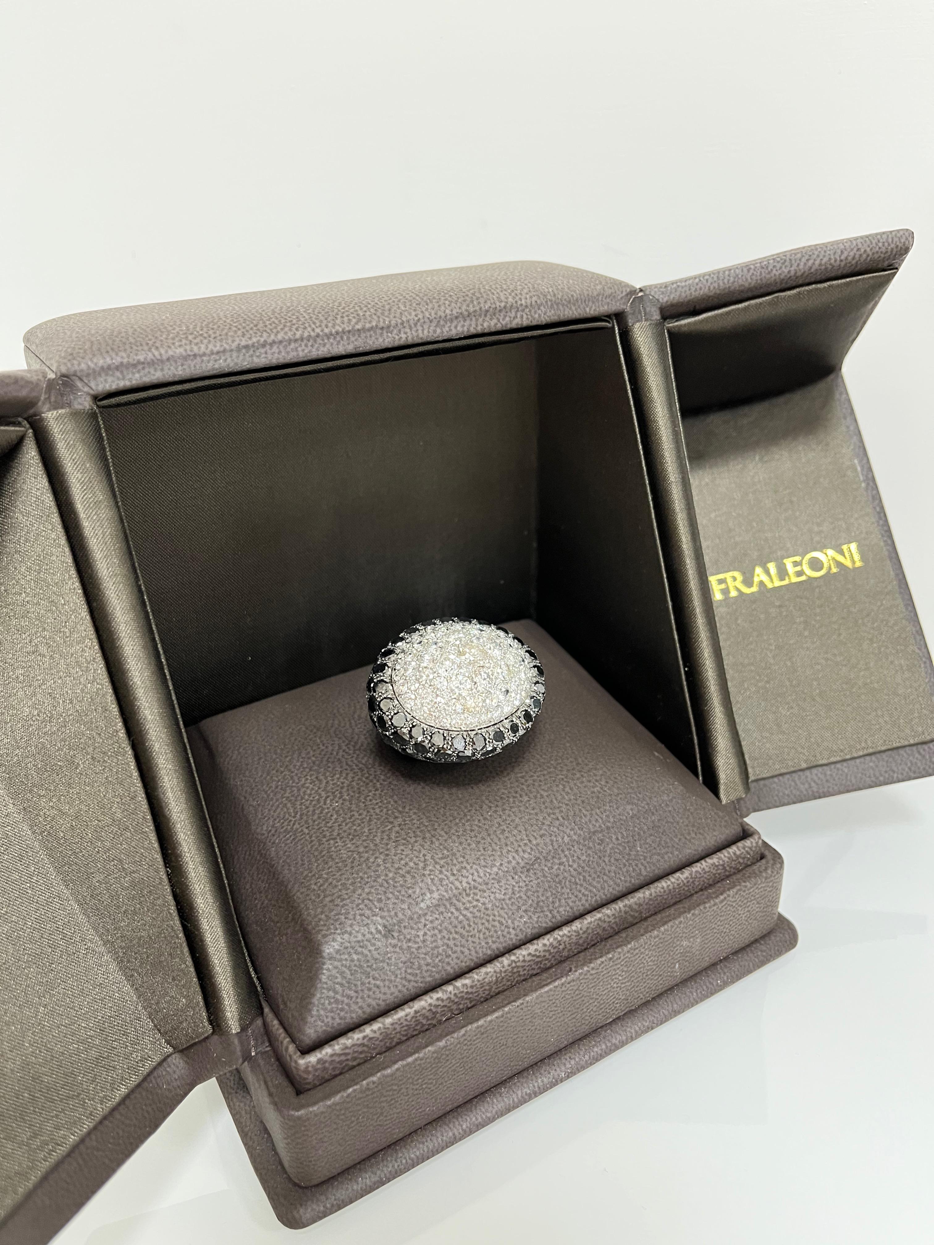 18 kt. white gold ring with round-cut diamonds and round-cut black diamonds.
This impressive cocktail ring is hand-made in Italy and signed by Fraleoni.
Fraleoni is an Italian brand, based in the centre of Rome.
The ring is shaped as an oval.
The