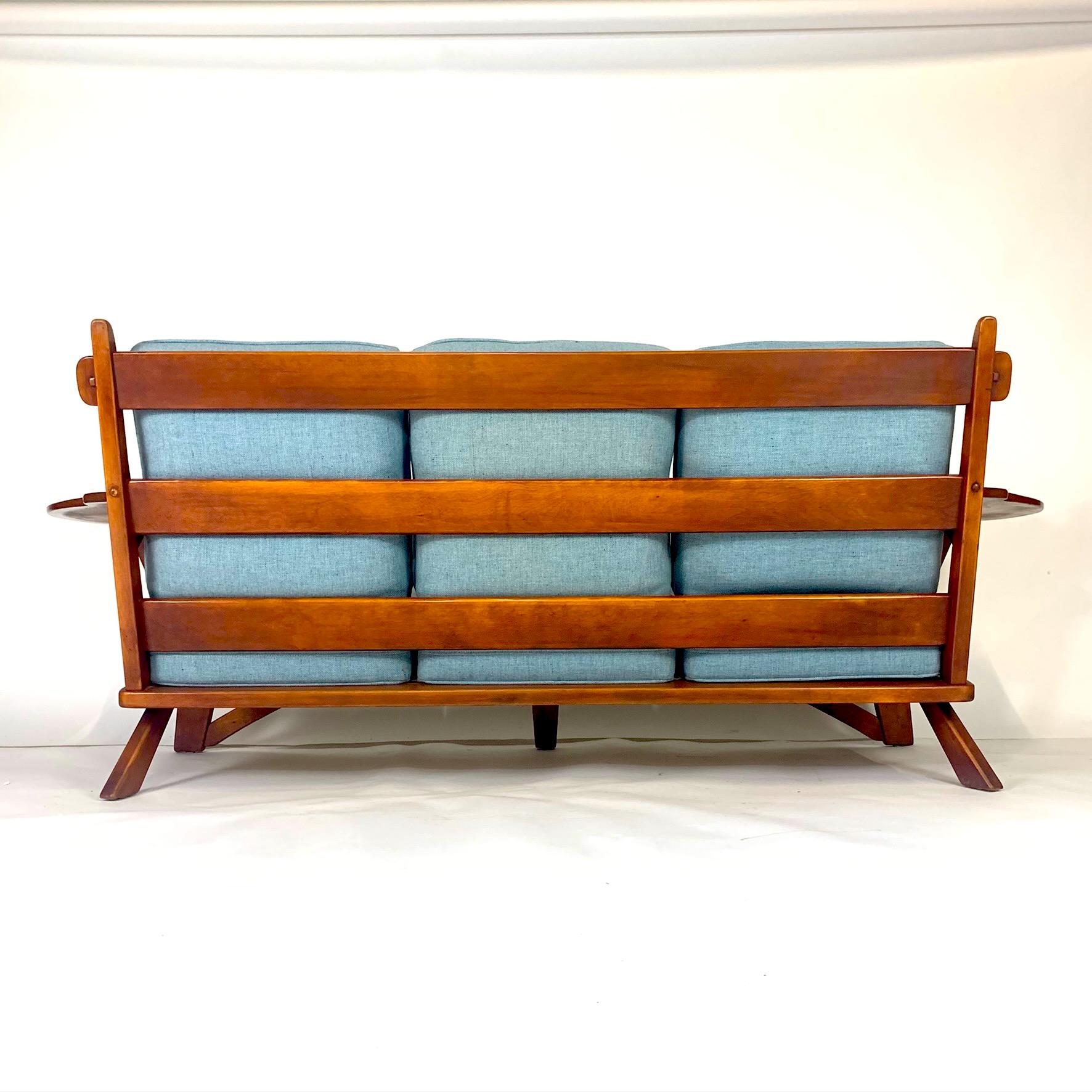 A beautifully preserved original finish paddle arm sofa by Cushman from the 1930s colonial creations line designed by William DeVries. Model No. 5-184-3. This sofa is very comfortable and stylish and would work well with Mid-Century Modern or