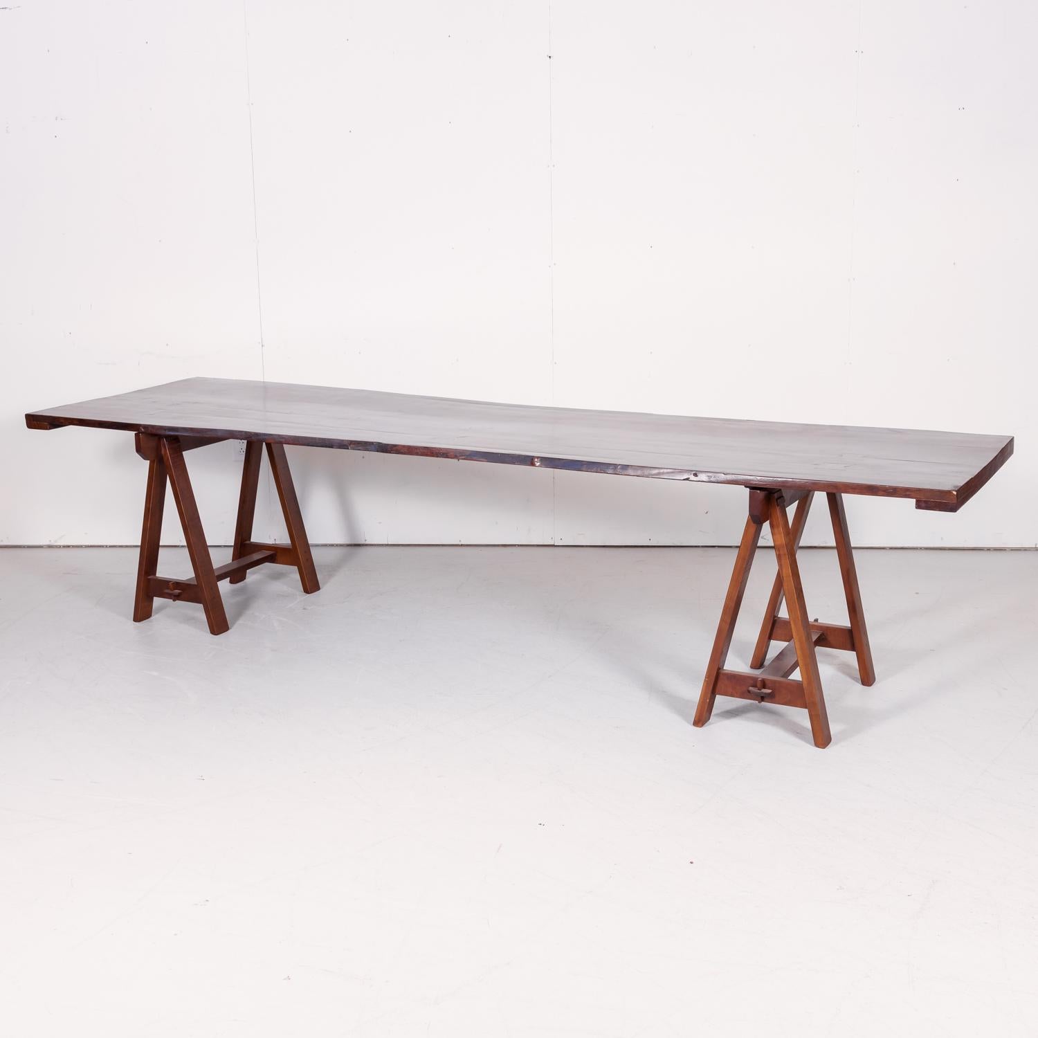 Impressive live edge apple harvest trestle table custom made in France of 19th century reclaimed cherry wood by a skilled French ebéniste after an 18th century harvest table we found in Normandy. At 10.5 feet in length, this beautiful plank top