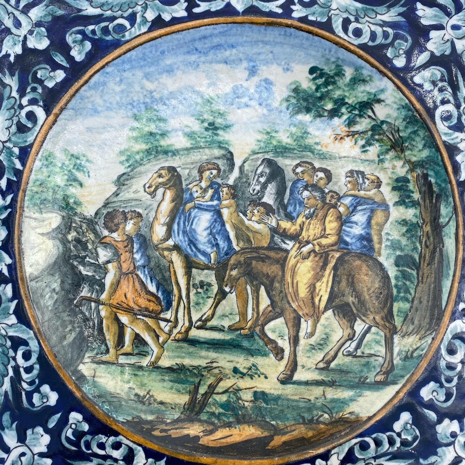 Very impressive large hand painted Italian Majolica plate made of tin glazed earthenware from the early 1800s. The biblical scene shows possibly the Virgin Mary (or another noblewoman and baby) and baby Jesus on horseback with other villagers and