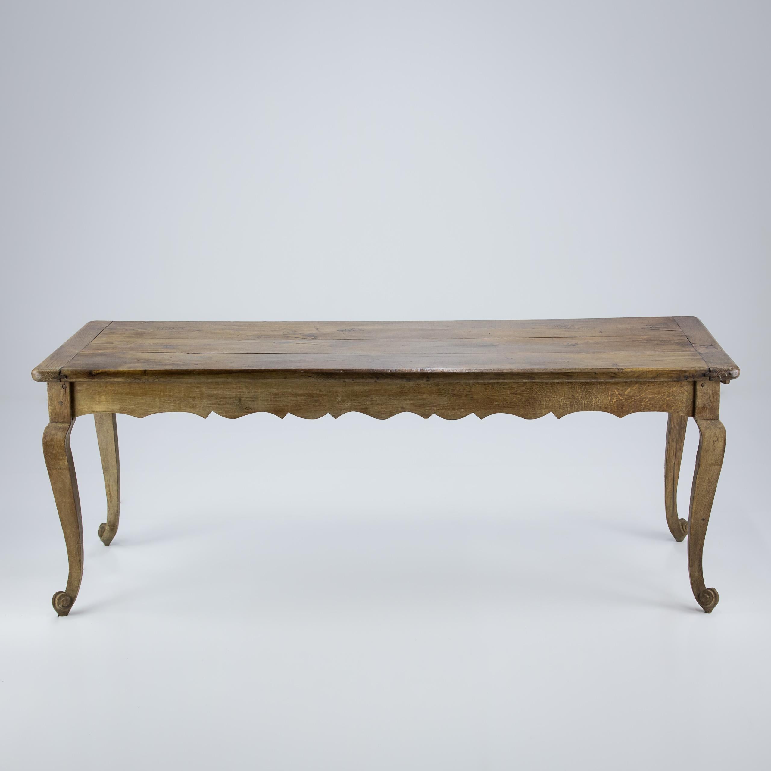 Impressive Louis XV style Country Farmhouse Table. Impressive Scroll foot and Cabriole leg. Robust, Thicker than expected three piece top with cleated ends showing pleasing shrinkage. Well proportioned, elegant underskirt. Good patination and wear.