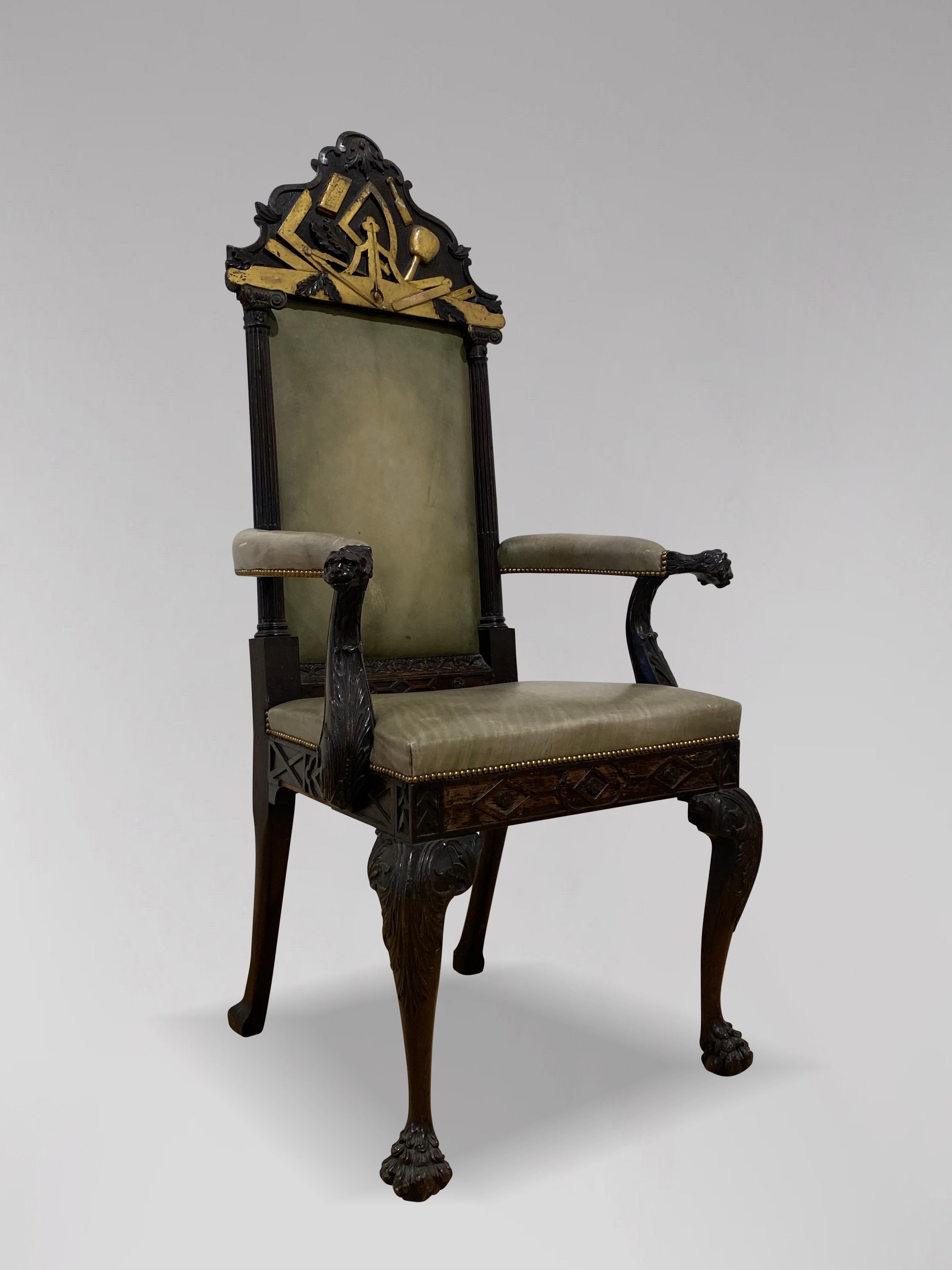 Impressionnant fauteuil trône maçonnique du XIXe siècle en acajou, partiellement doré. Le haut dossier, orné de plaques maçonniques sculptées et dorées, est surmonté d'un dossier en cuir vert à colonnes corinthiennes de chaque côté, flanqué