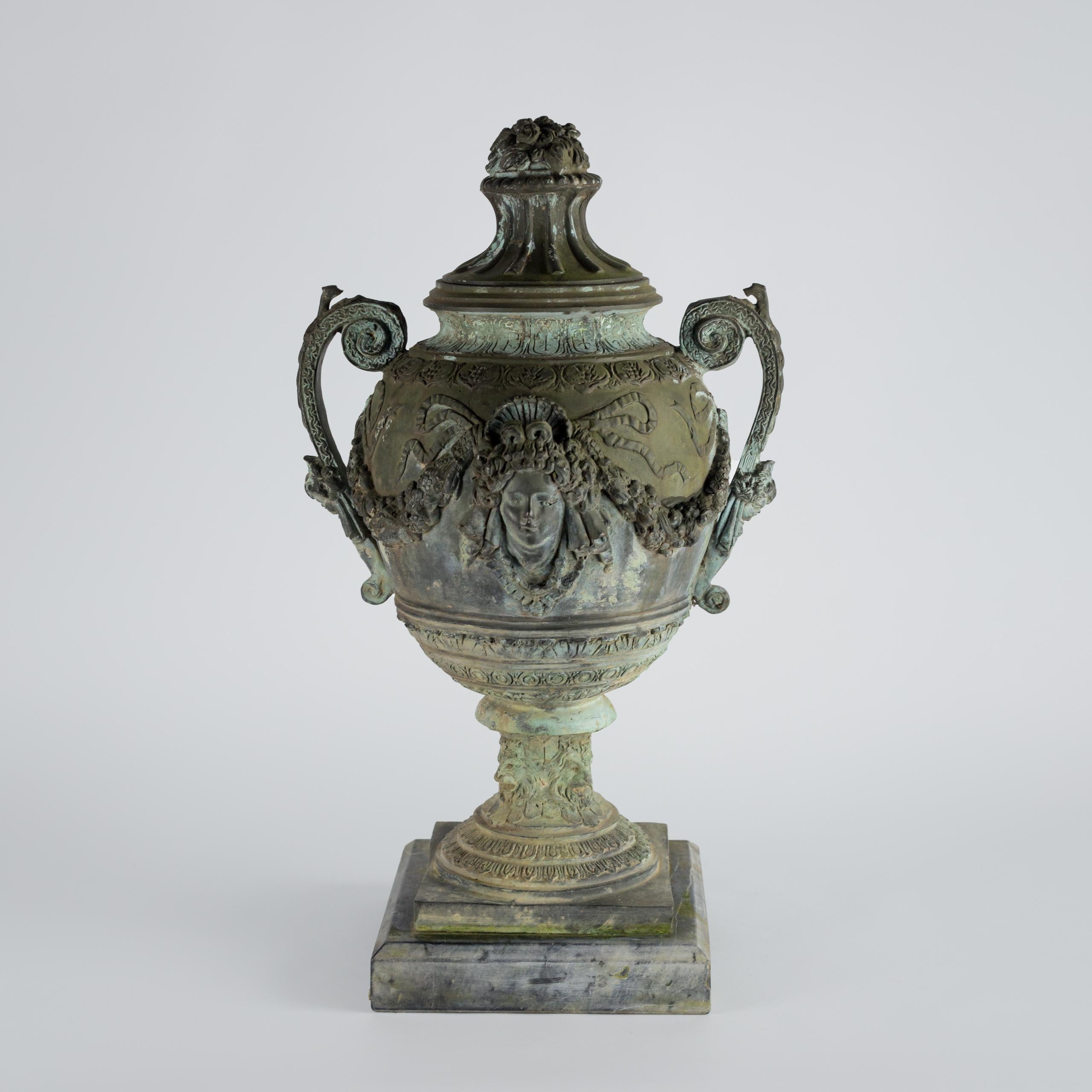Bronzeurne aus dem späten 19. Jahrhundert. Beeindruckende neoklassizistische Urne aus Bronze aus dem 19. Jahrhundert, die auf einem Marmorsockel steht, der aus vier fein gearbeiteten Löwenmasken besteht. Üppig und aufwändig mit Masken und Bändern