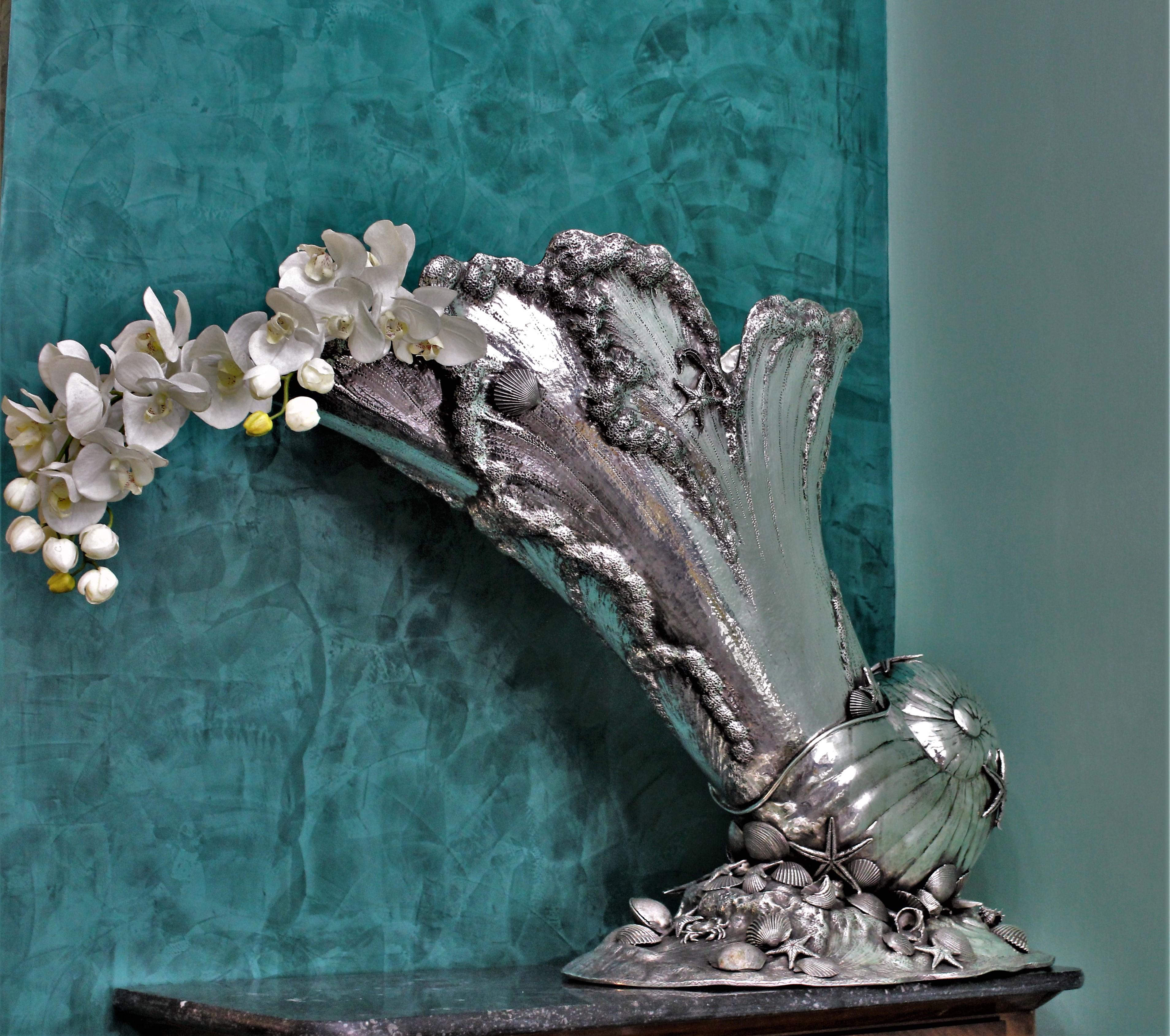 Impressive silver cornucopia centerpiece shell shaped entirely embossed and engraved by hand and with applications of silver cast sea fruits, shells and sea stars.
The large base is represented by sea rock surmounted by sea fruits, shells and sea