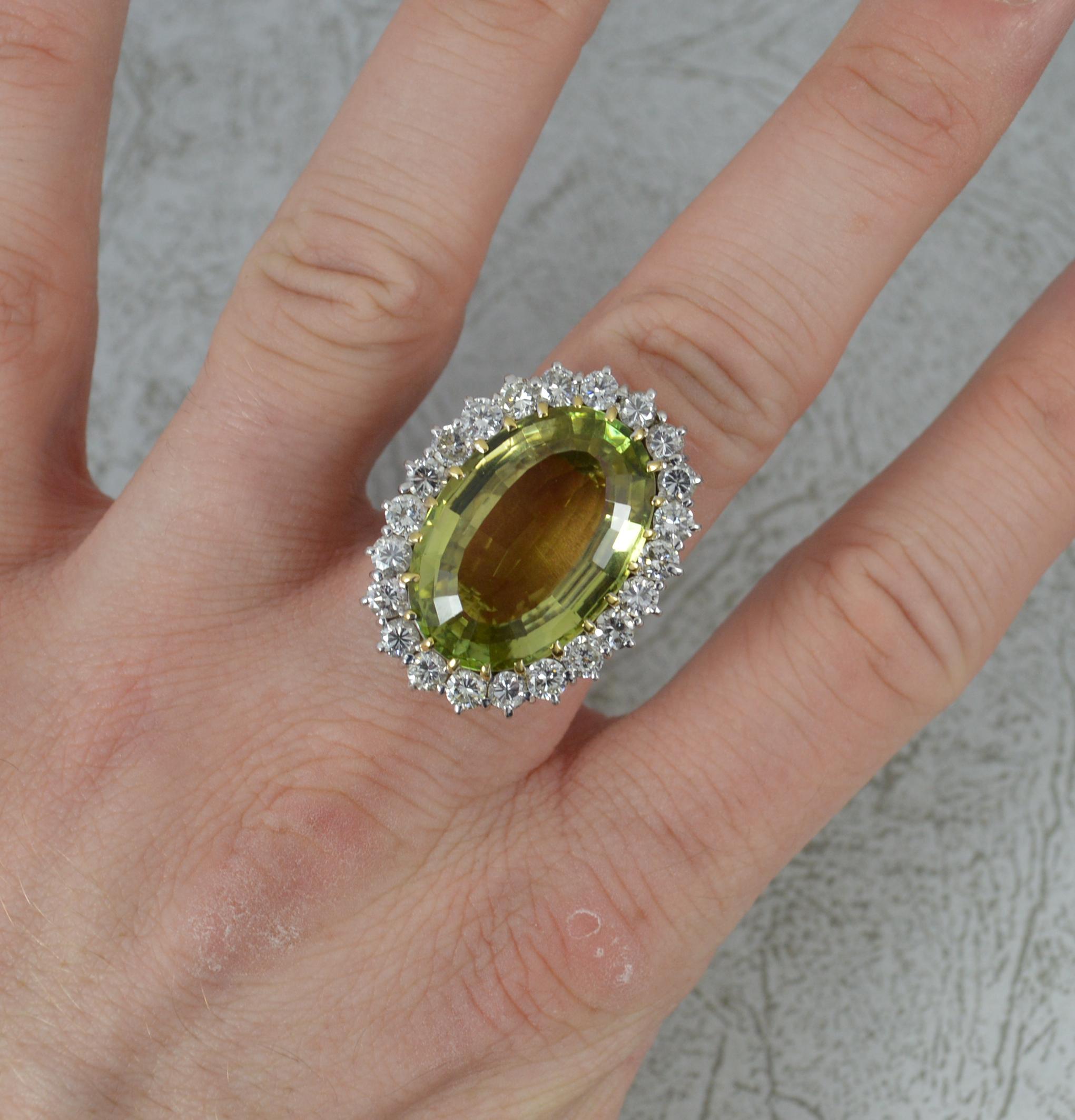 A classically shaped gemstone and diamond cocktail ring.
Solid 18 carat white gold example throughout.
Set with an oval cut green quartz to centre. 15mm x 22mm. Surrounding are twenty two natural round brilliant cut diamonds to total 2.20cts