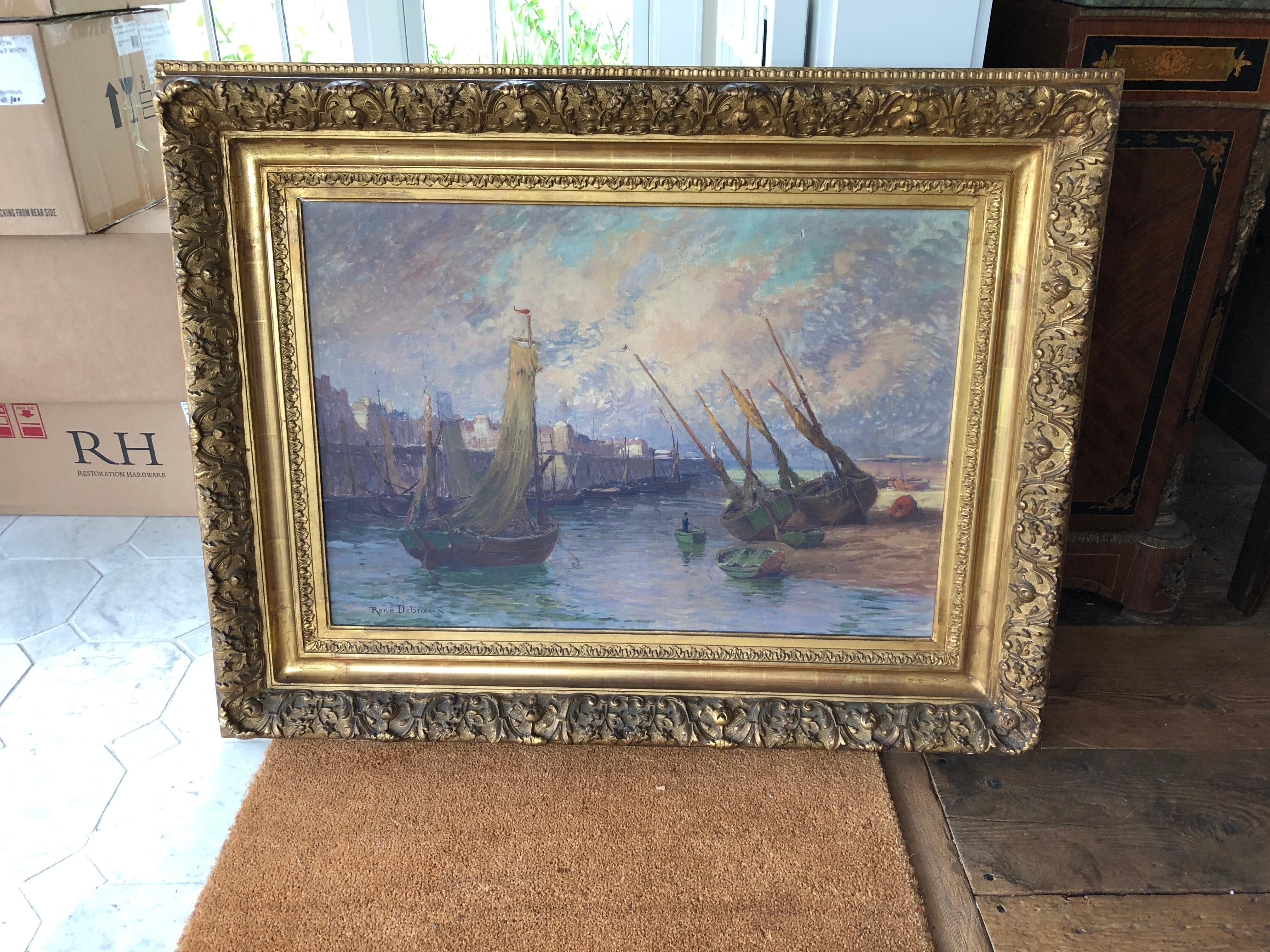 Bought in Lyon, France, this significant and large sized impressionist painting is by listed French artist René Charles Louis Debraux (1868-1938). Depicting a seaside town in France, several schooners and a rowboat are shown next to a classic French