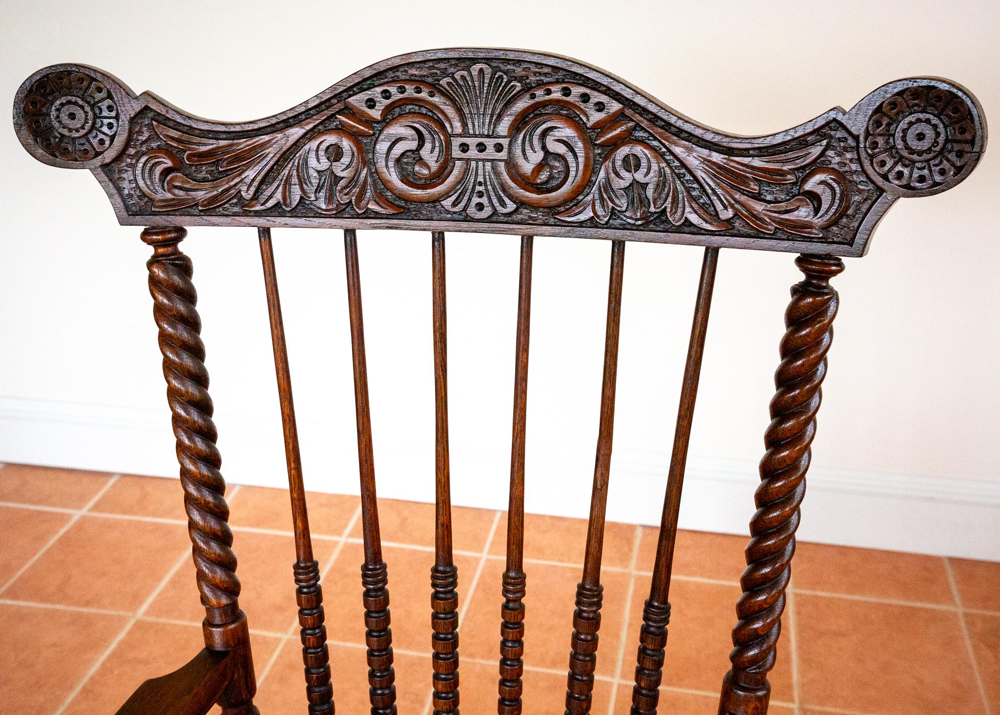Una splendida poltrona Windsor di grandi dimensioni, estremamente imponente e molto rara, ornata di intagli e in splendide condizioni d'epoca. Realizzata probabilmente in Inghilterra all'inizio del XX secolo, questa poltrona in quercia di grande