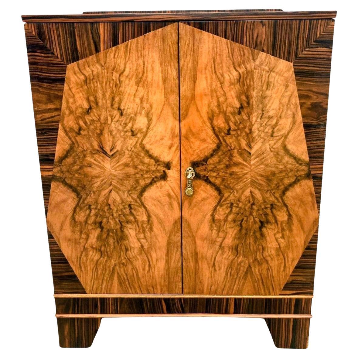 Excepcional armario original Art Déco para la ropa blanca, chapado en nogal muy labrado con llamativos detalles de ébano de macassar. El mueble exhibe una geometría Decó clásica, proporciones refinadas y superficies bellamente emparejadas que