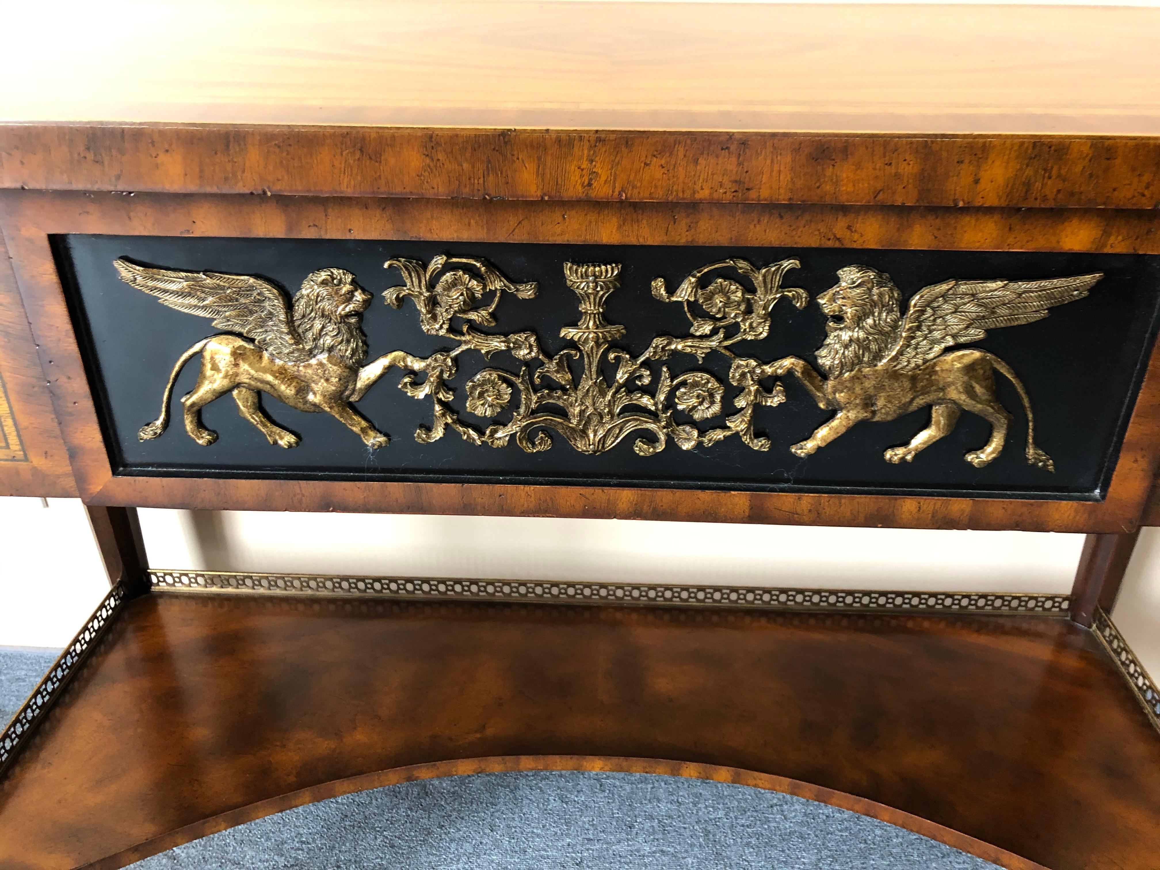 Very rich banded bookmatched crotch mahogany sideboard or console having 3 drawers and gorgeous brass embellishments, especially on the center drawer with winged horses and neoclassical curlicues.