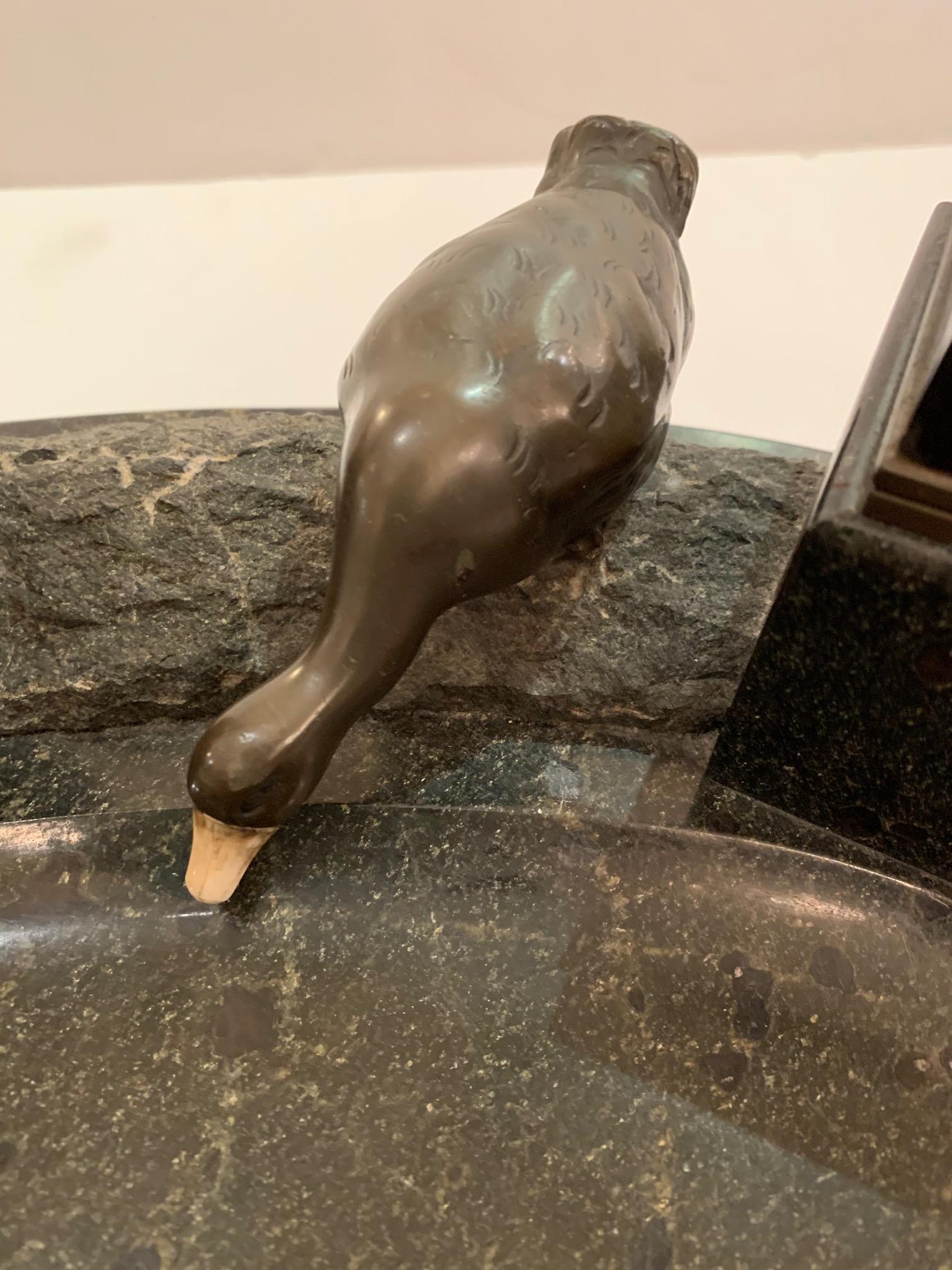 Incredible black marble inkwell that is truly an objet d'arte, having two lyrical bronze ducks with bone beaks, as though perched at the side of a pond and two square ink wells lined in brass. Looks like it could be by the artist, Andre Villien, but