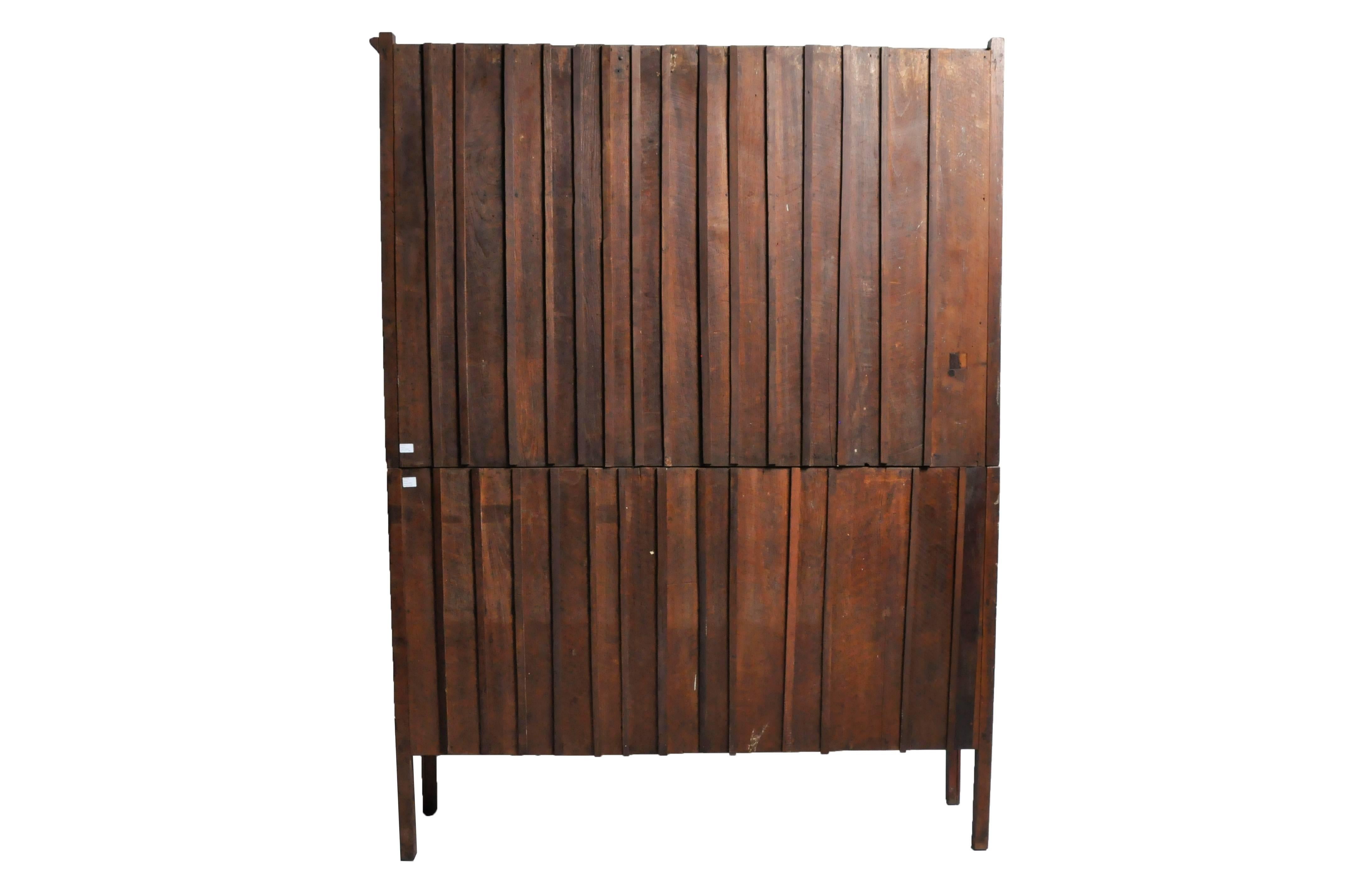 This handsome cabinet comes in two parts; both the top and bottom have two sets of glass panel doors that open to compartments lined with shelves. It's scale and ample storage make this a perfect book display for an office or library. Made from teak