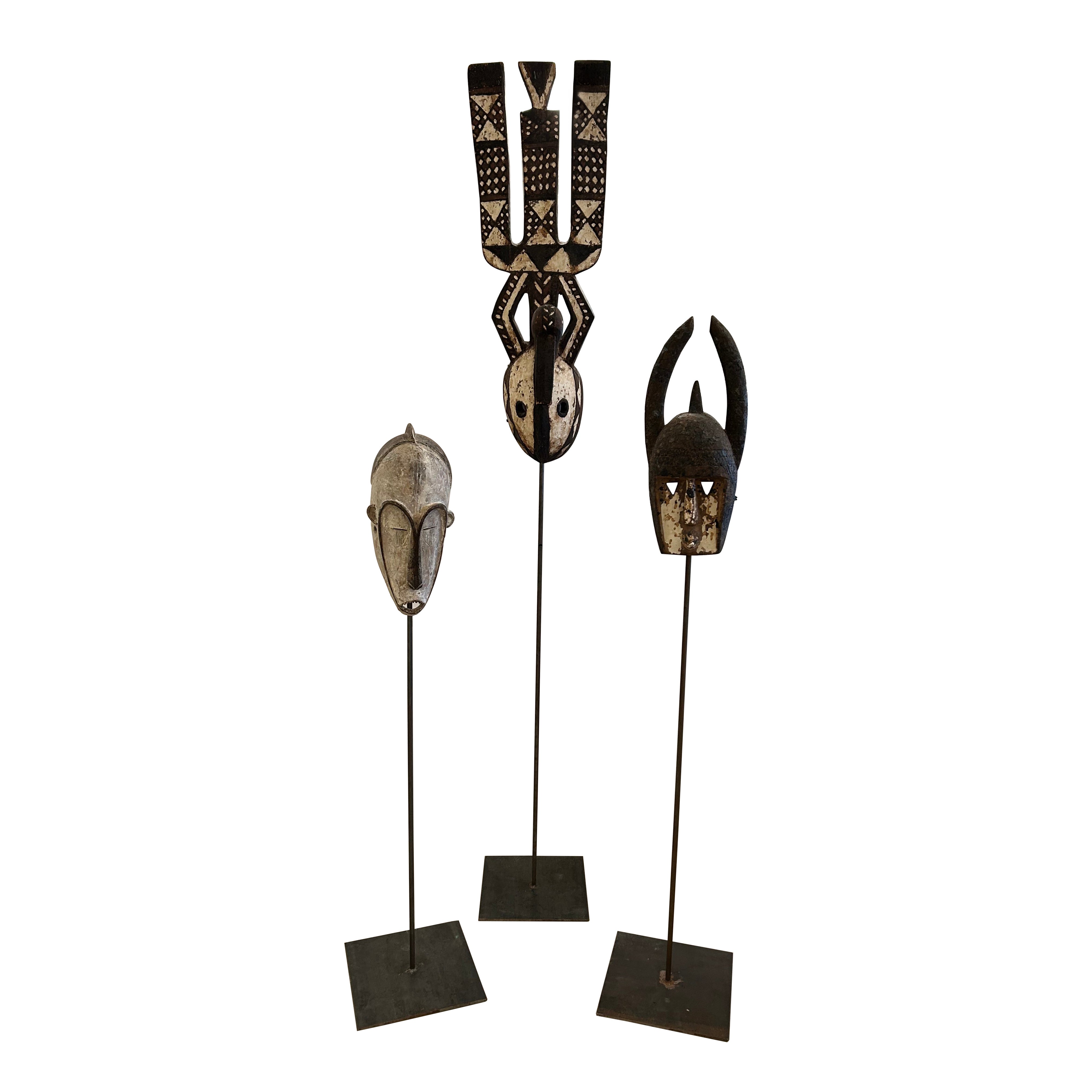 Impressive Collection of African Carved Wood Masks on Tall Custom Iron Stands For Sale