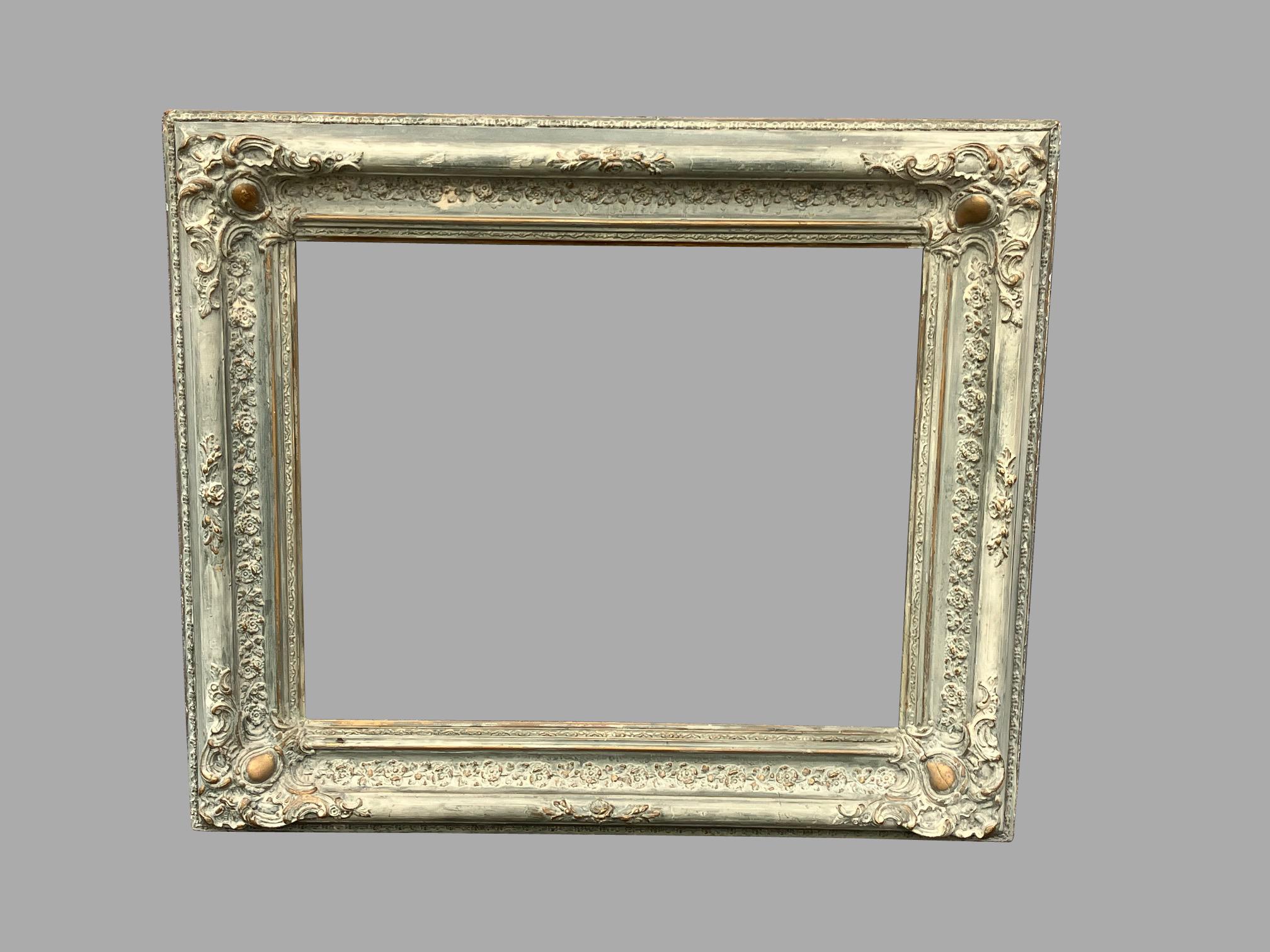 A well-executed 18th century Baroque picture frame of exuberant design, circa 1750. The paint appears to cover a formerly gilded frame. The back retains an old label in script, probably in Italian. Some gilding shows through at the bosses on all