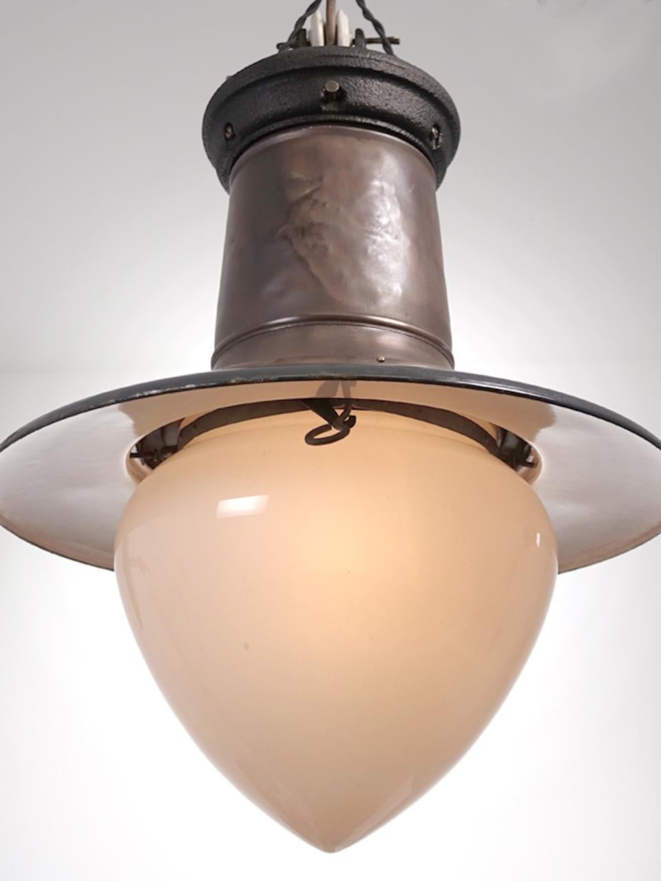 The finish of the bright copper and dark gray porcelain have just the right look. In addition the original white acorn milk glass dome make this impressive lamp a real standout. It has a 20 inch diameter shade and stands 28 inches tall. I believe